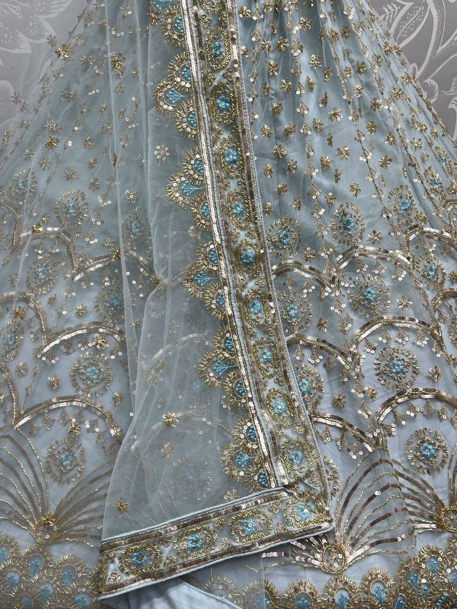 Light blue ethnic lehenga with gold and turquoise embroidery, sequins, and intricate floral patterns