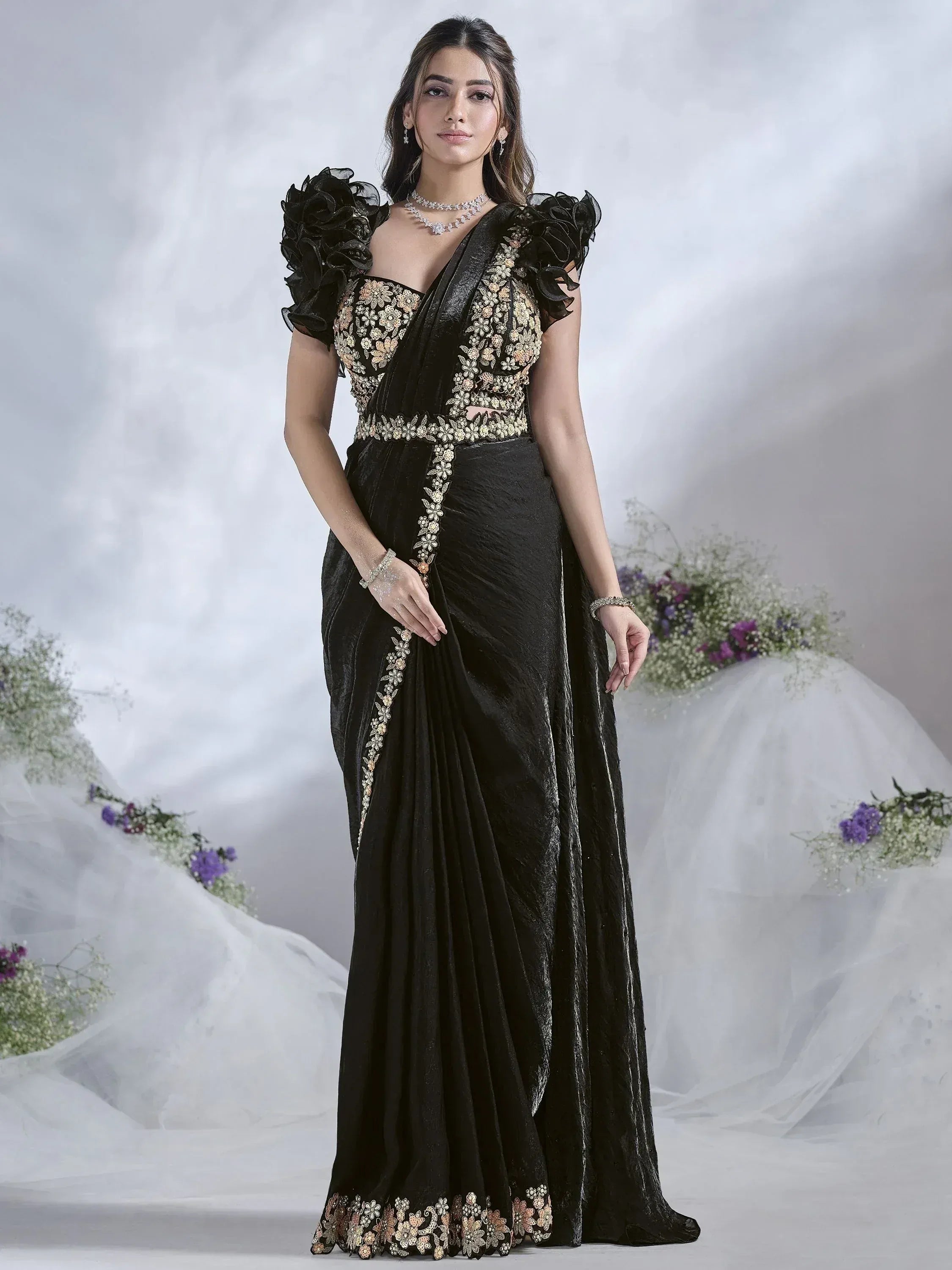 Black velvet saree with gold floral embroidery and ruffled sleeves, perfect for ethnic occasions