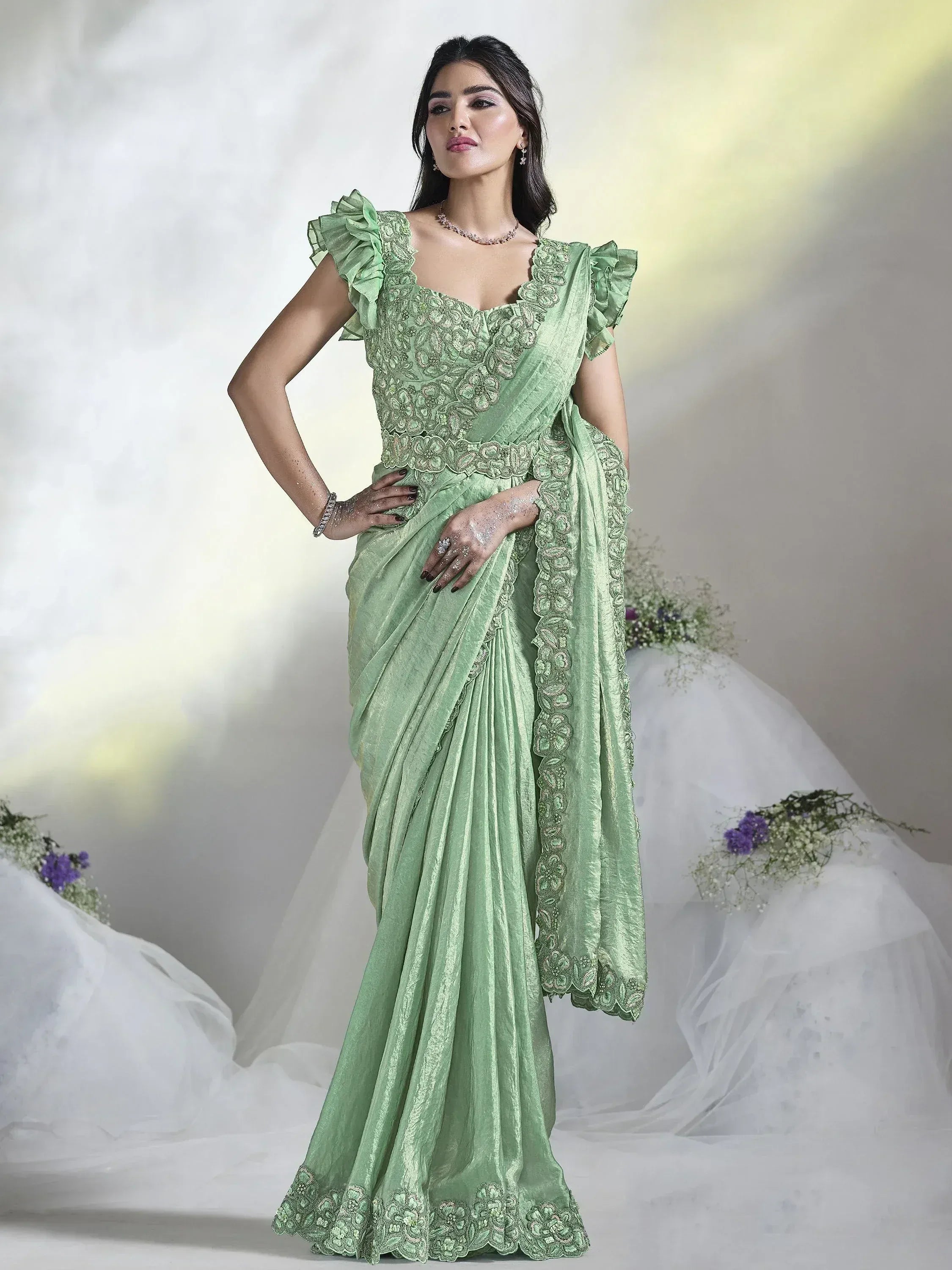 Mint green designer saree with floral embroidery, ruffled sleeves, and lace border for ethnic occasions