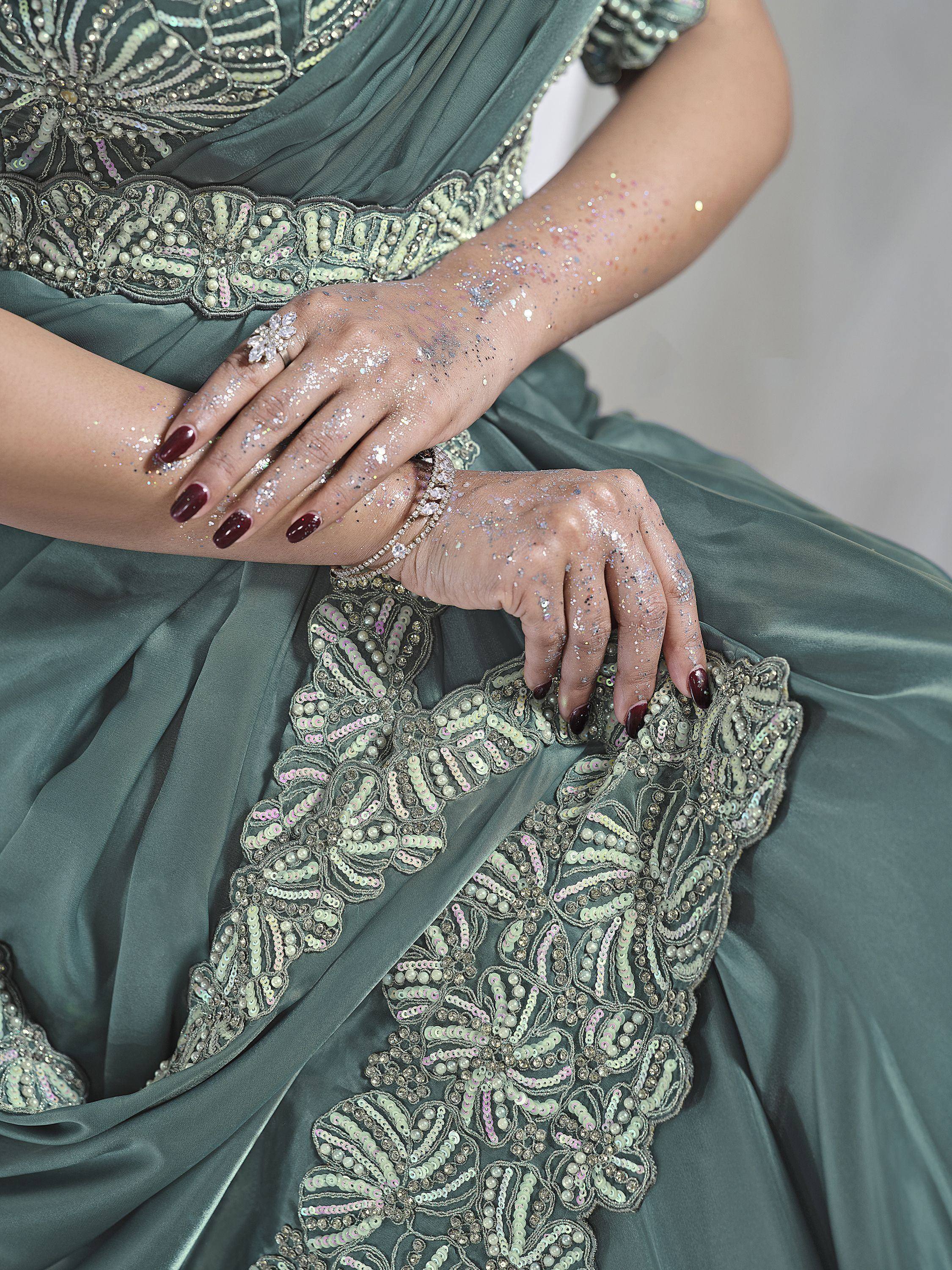 Elegant sage green ethnic gown with intricate sequin and pearl embroidery, perfect for festive occasions.