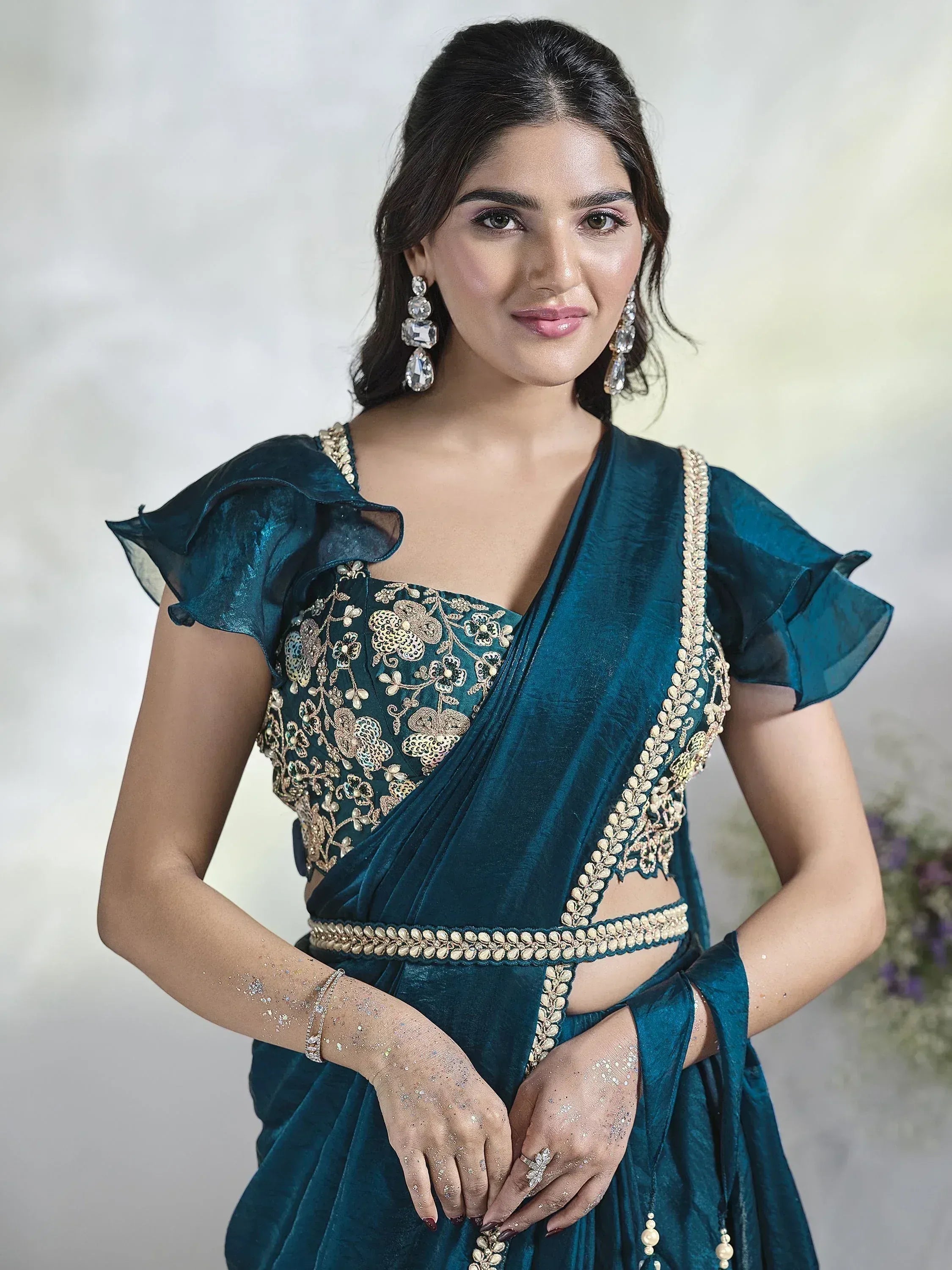 Teal velvet saree with gold floral embroidery and ruffle sleeves, perfect for Indian ethnic wear events