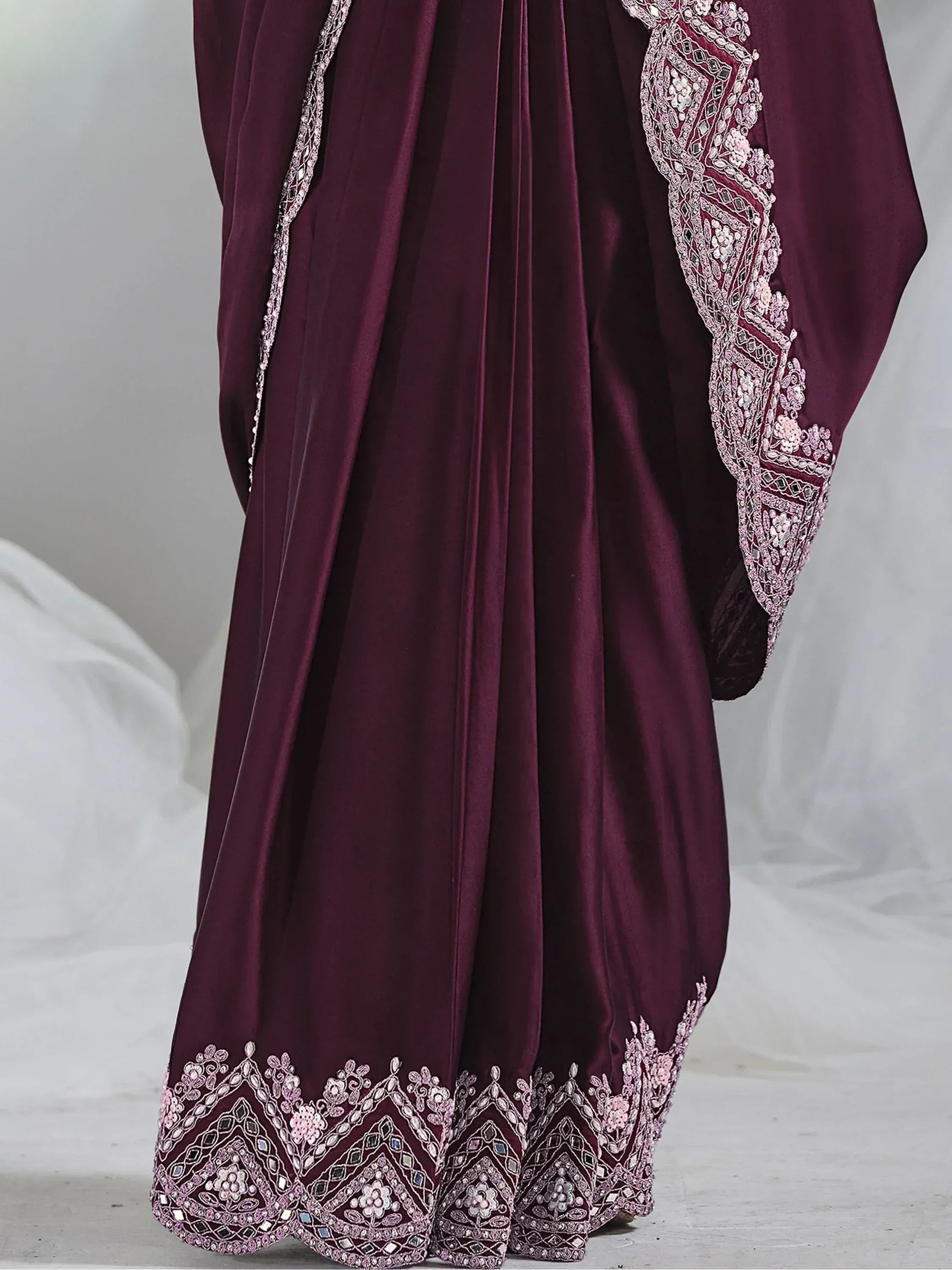 Elegant maroon ethnic gown with intricate floral embroidery and mirror work, perfect for Indian celebrations.