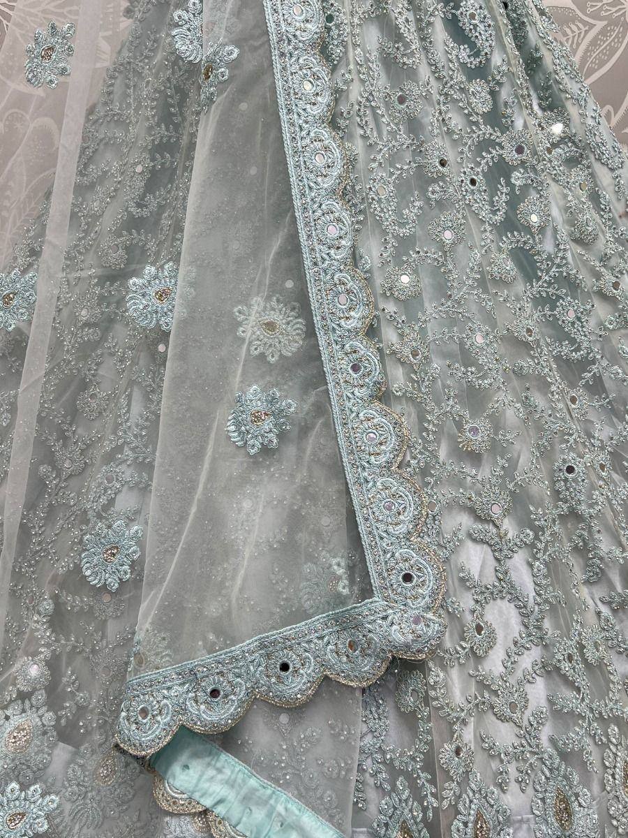 Light blue embroidered lehenga choli with intricate mirror work and floral motifs, perfect for weddings.