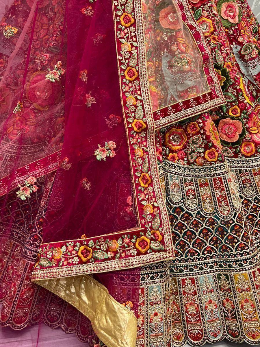 Richly embroidered maroon lehenga choli with floral motifs and velvet dupatta, perfect for Indian weddings.