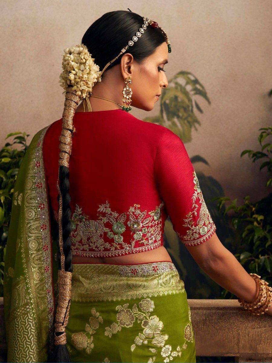 Woman in red embroidered blouse and green floral saree with traditional Indian jewelry and gajra