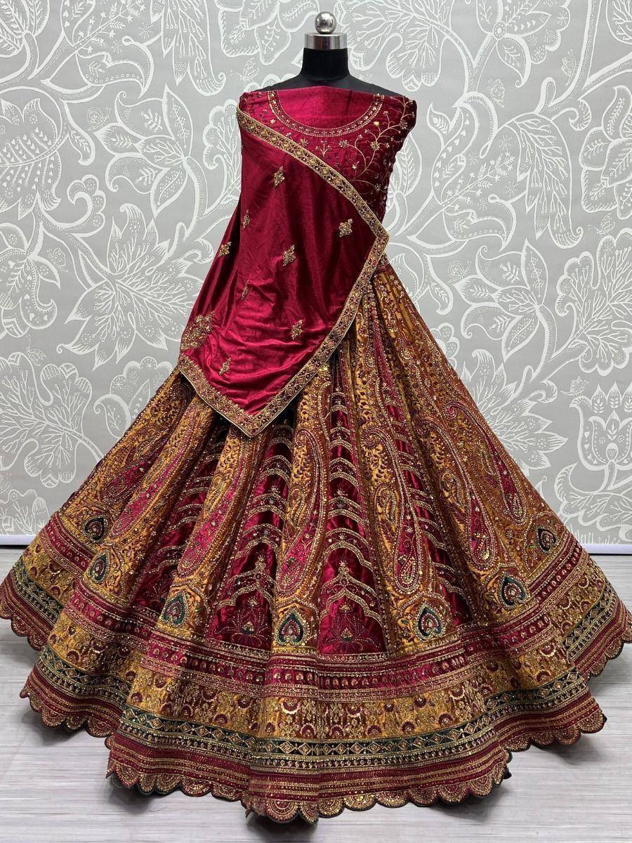 Rich maroon velvet lehenga choli with gold paisley embroidery, perfect for Indian weddings and festive occasions.