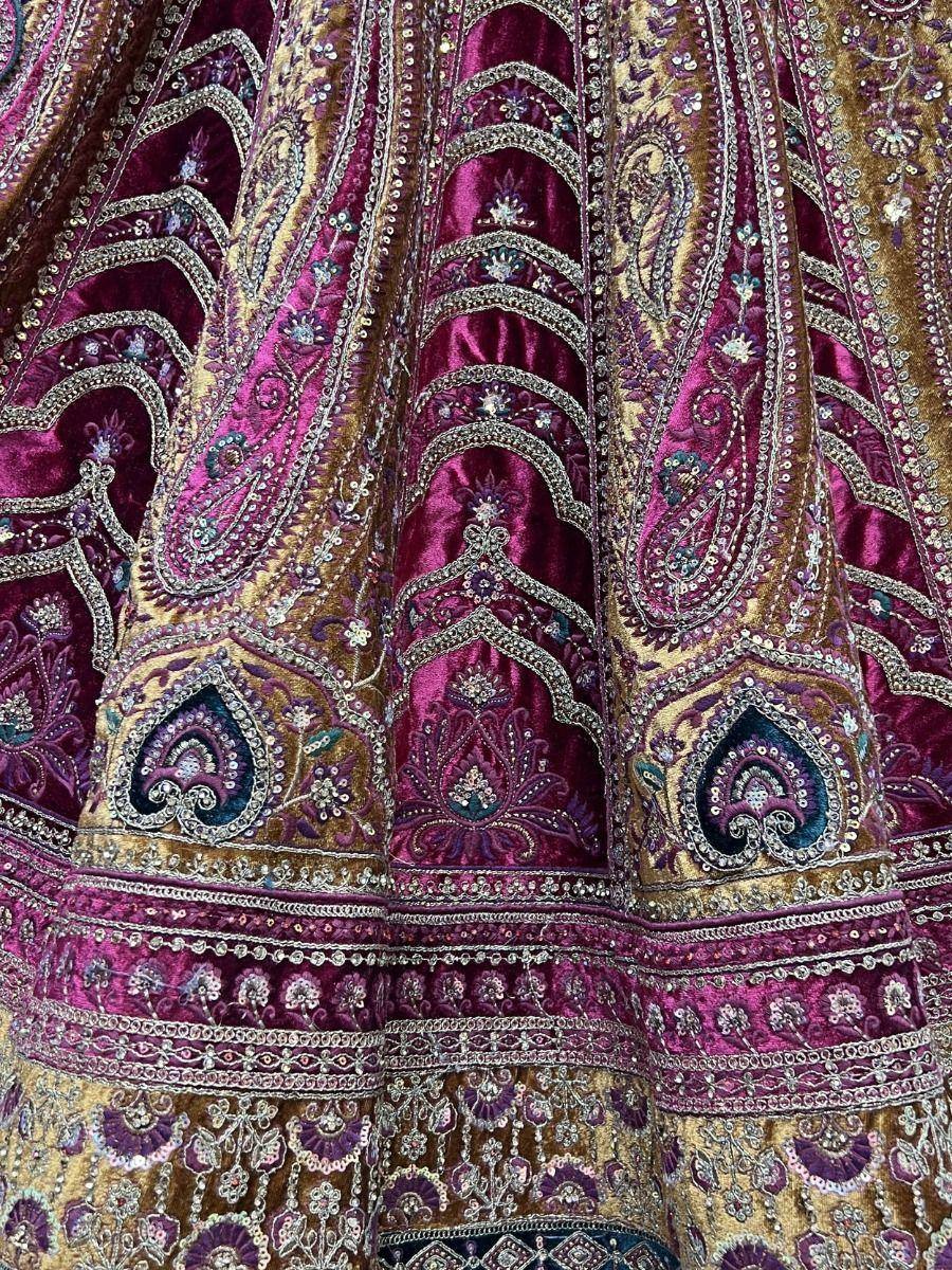 Richly embroidered maroon and gold lehenga with intricate paisley and floral motifs, perfect for Indian ethnic wear.