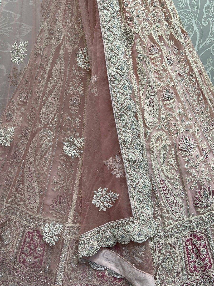 Elegant dusty pink lehenga with intricate gold and silver embroidery, perfect for Indian weddings and festive occasions.