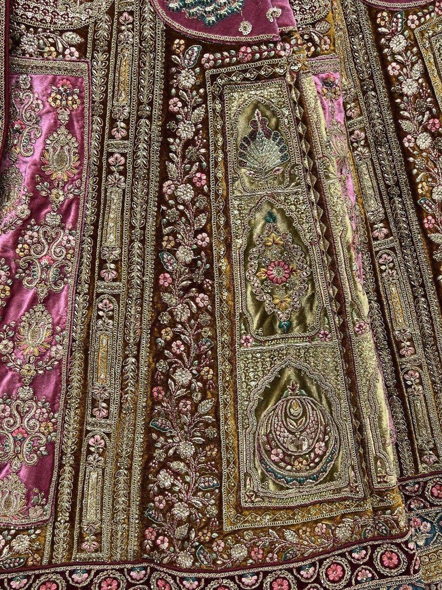 Luxury Indian ethnic lehenga with intricate floral embroidery, velvet fabric, and gold threadwork details.