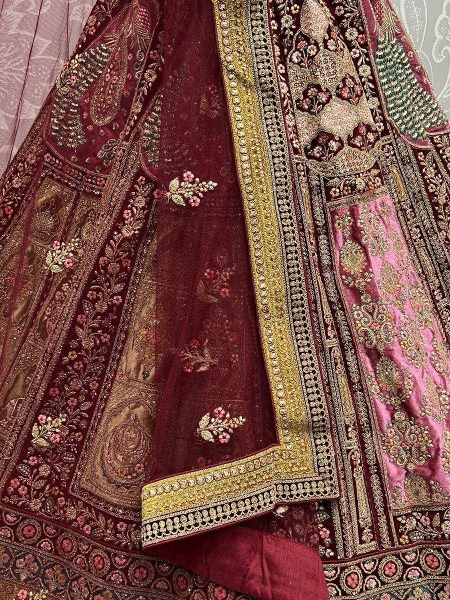 Luxury maroon lehenga choli with intricate gold embroidery and floral motifs, perfect for Indian weddings.