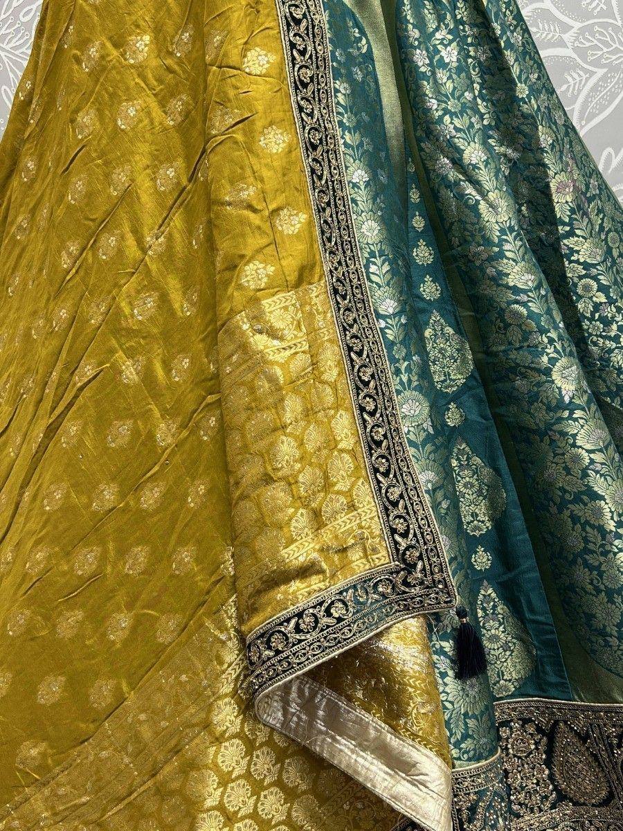Luxury Indian lehenga choli with gold and teal brocade, intricate floral embroidery, and ornate border detailing.