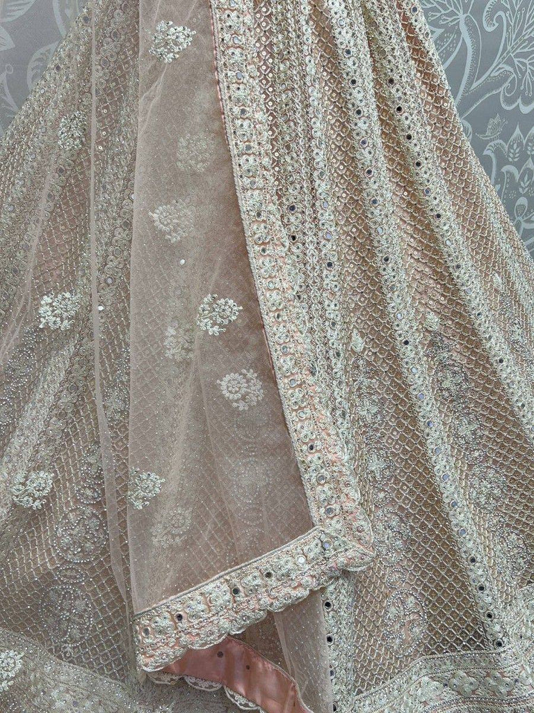 Elegant beige lehenga choli with intricate silver embroidery and mirror work, perfect for Indian ethnic wear.