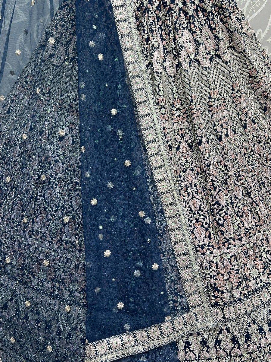 Dark blue embroidered lehenga with floral motifs and sheer dupatta, perfect for Indian ethnic wear occasions.