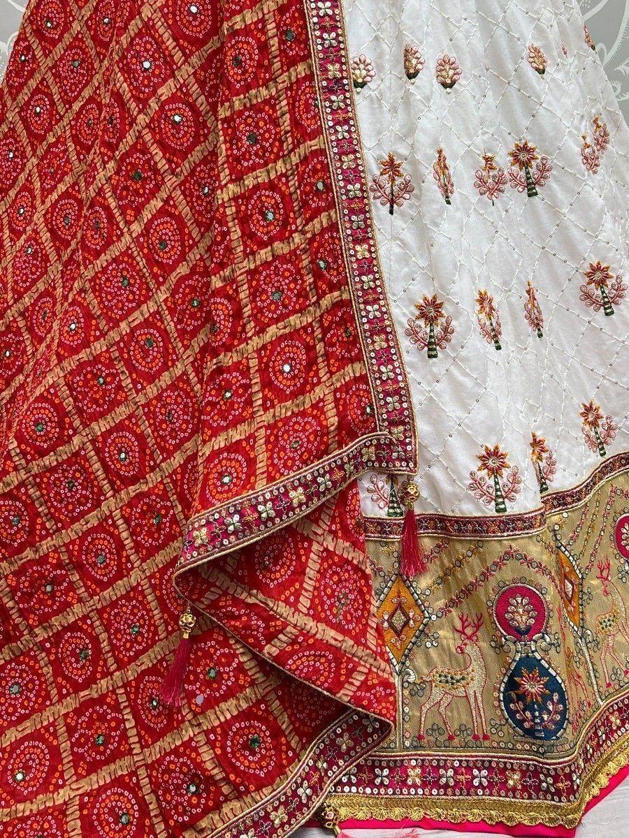 Red and white embroidered Indian lehenga with mirror work, floral motifs, and deer design, perfect for ethnic occasions