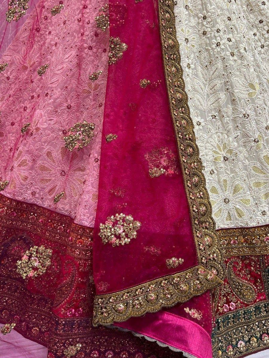 Designer lehenga choli with intricate embroidery, floral motifs, and velvet fabric in pink, magenta, and white tones