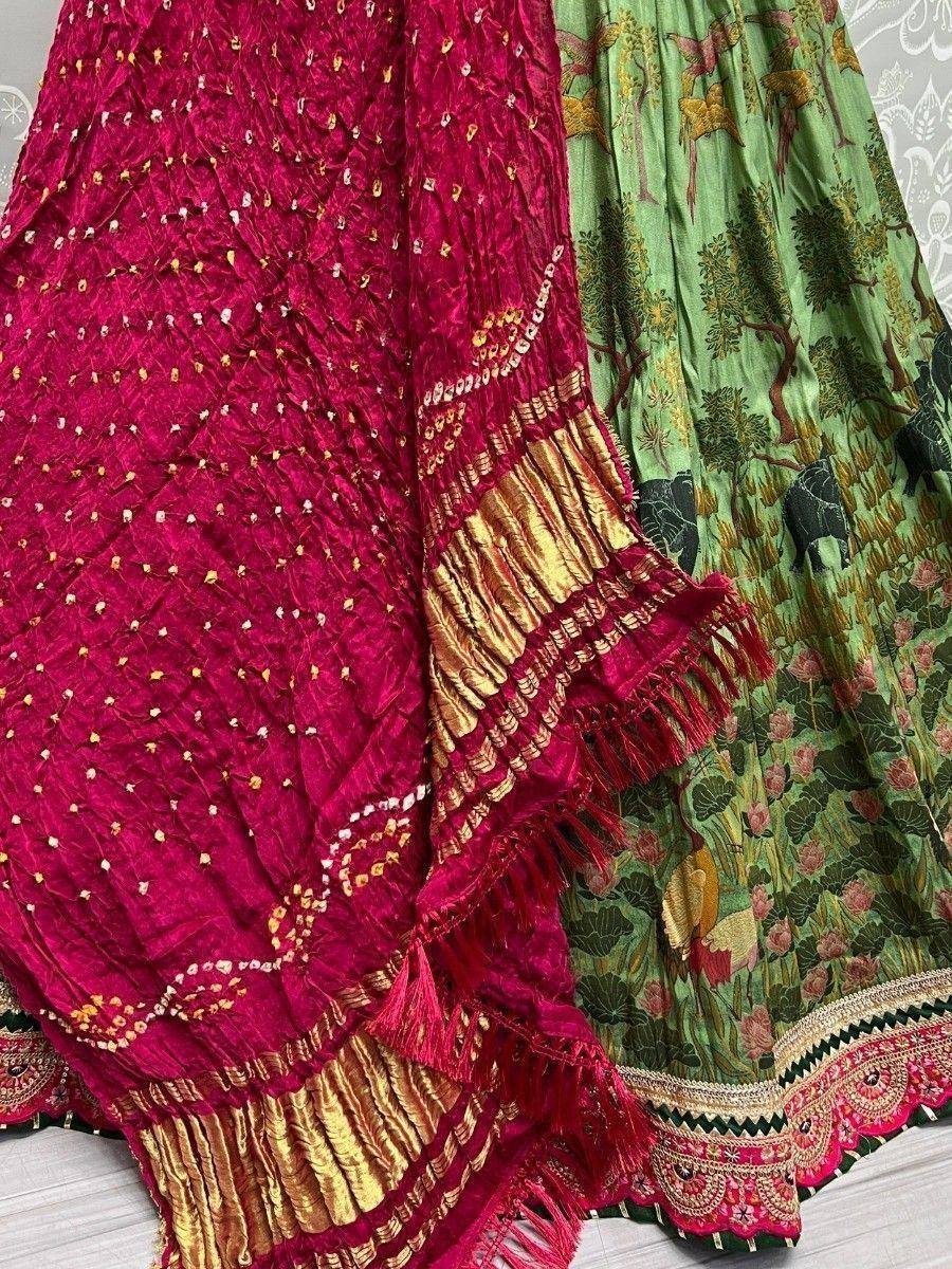 Red embroidered dupatta with gold trim and green printed lehenga skirt, Indian ethnic wear