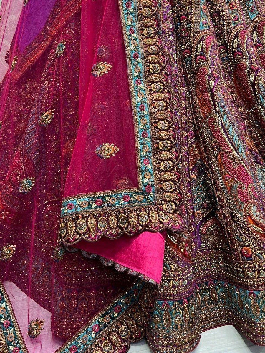 Luxury maroon lehenga choli with intricate gold embroidery and turquoise border, perfect for Indian weddings