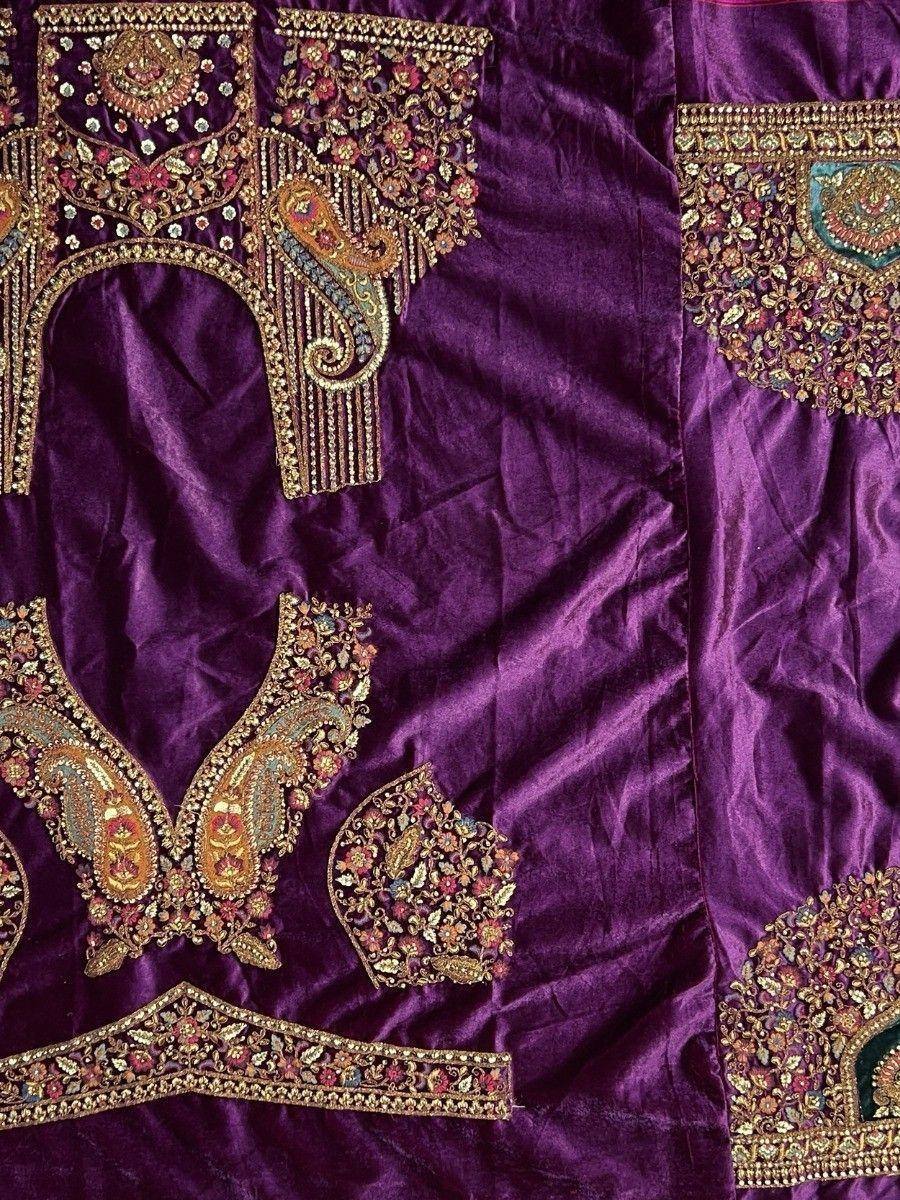 Purple velvet lehenga choli with intricate gold embroidery and floral motifs, perfect for Indian ethnic wear.