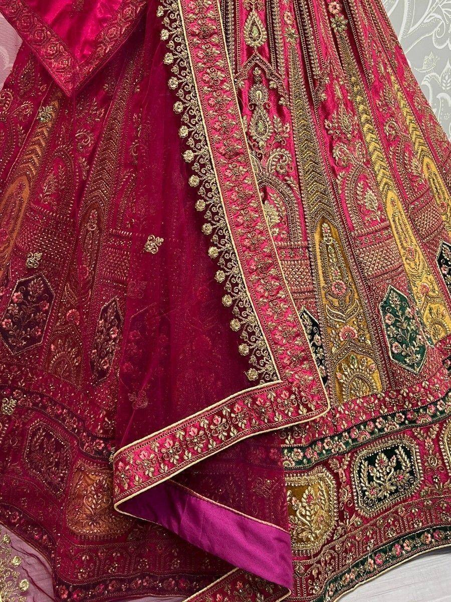 Richly embroidered maroon lehenga choli with gold and green detailing, perfect for Indian ethnic wear