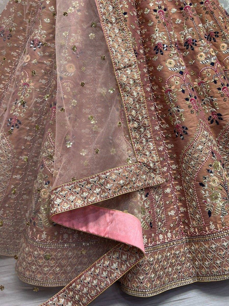 Elegant brown lehenga choli with intricate gold and pink embroidery, perfect for Indian ethnic wear occasions.