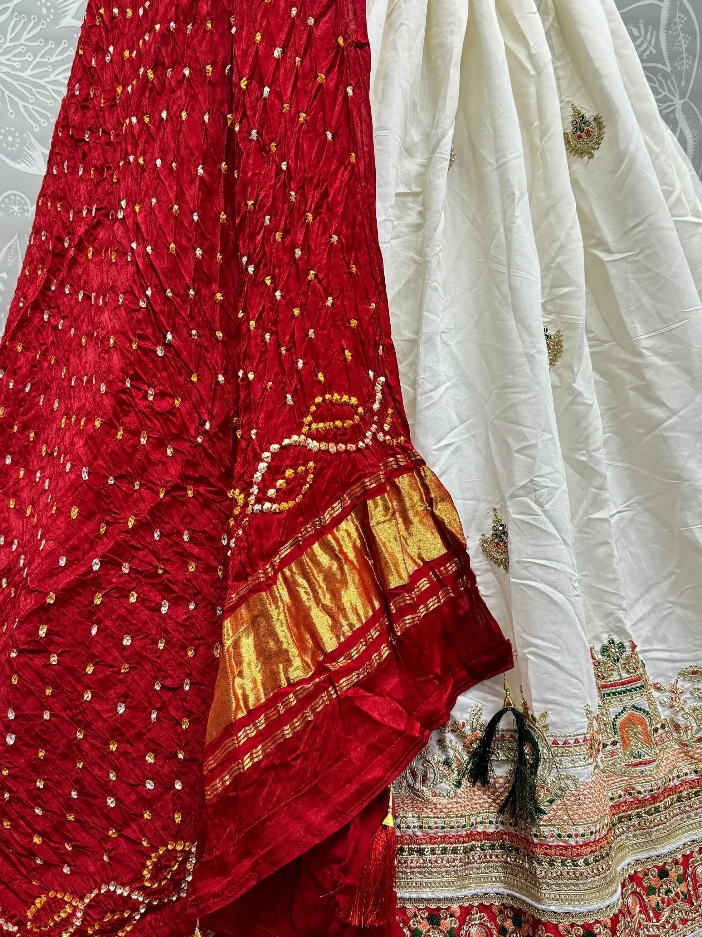 Red and white ethnic lehenga with gold embroidery and mirror work, perfect for Indian weddings and festive occasions.