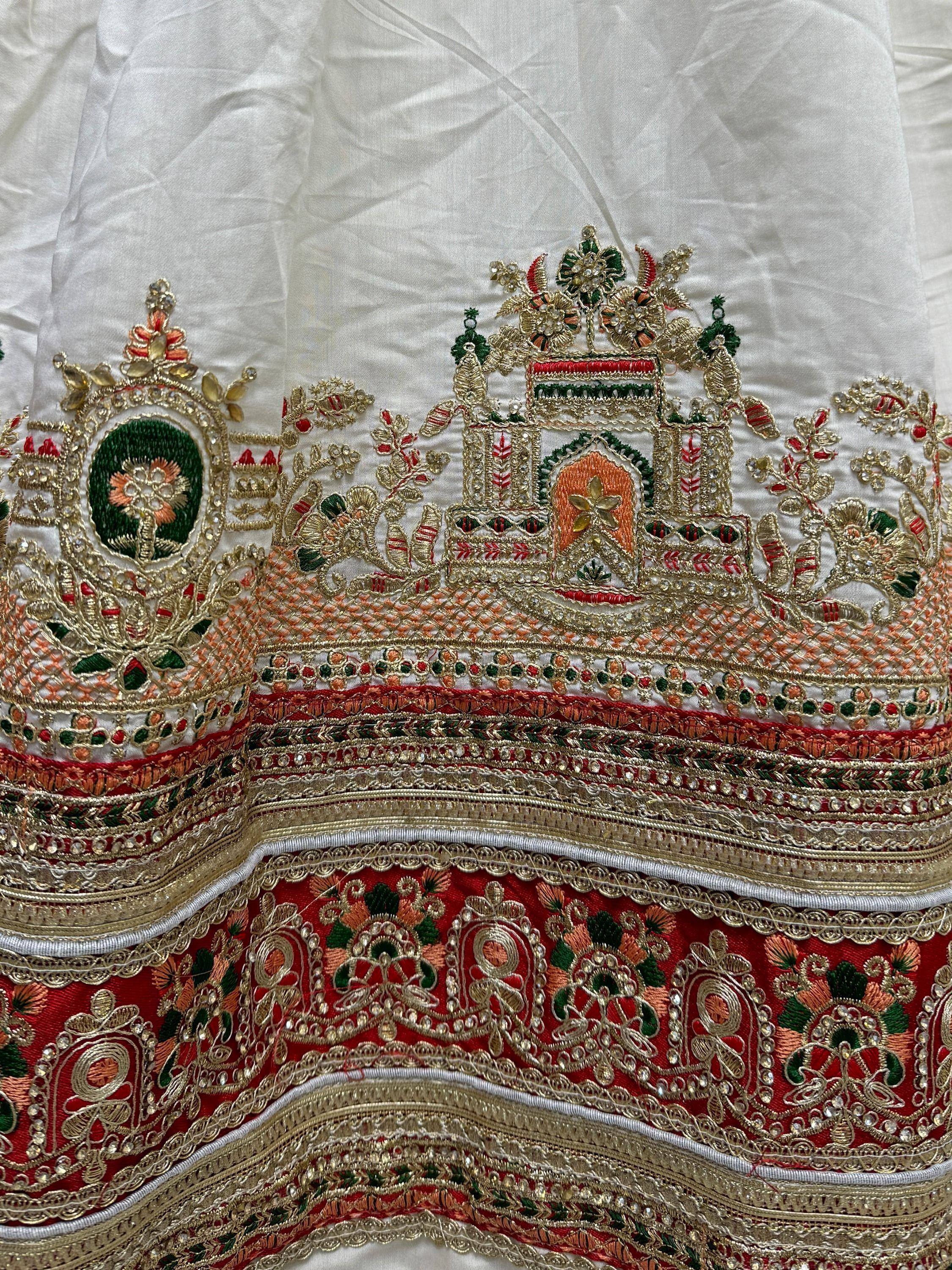 White and red ethnic lehenga with intricate gold embroidery and temple motifs