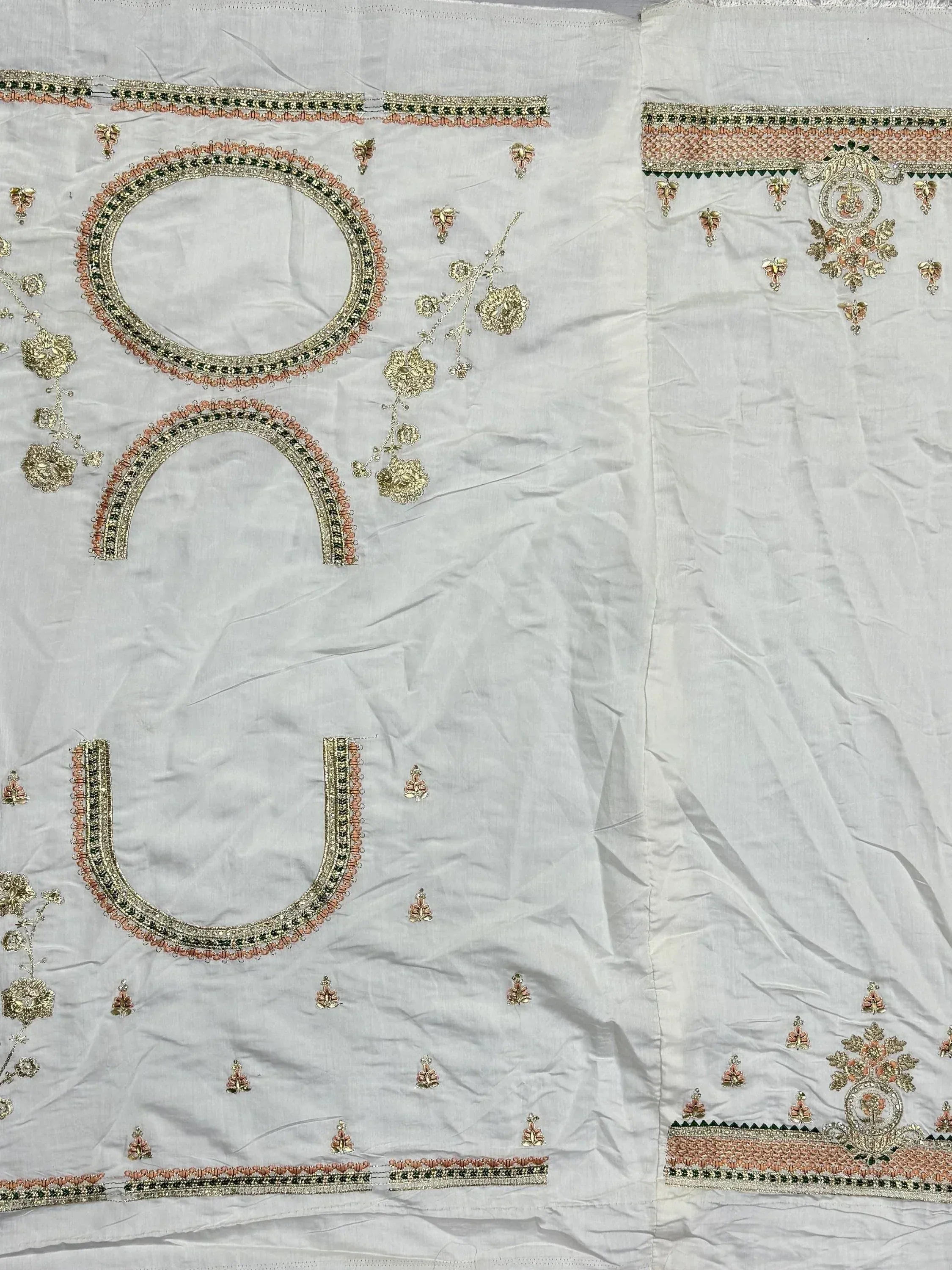 White ethnic wear with gold and peach embroidery, floral motifs, and detailed borders for designer lehenga or saree.