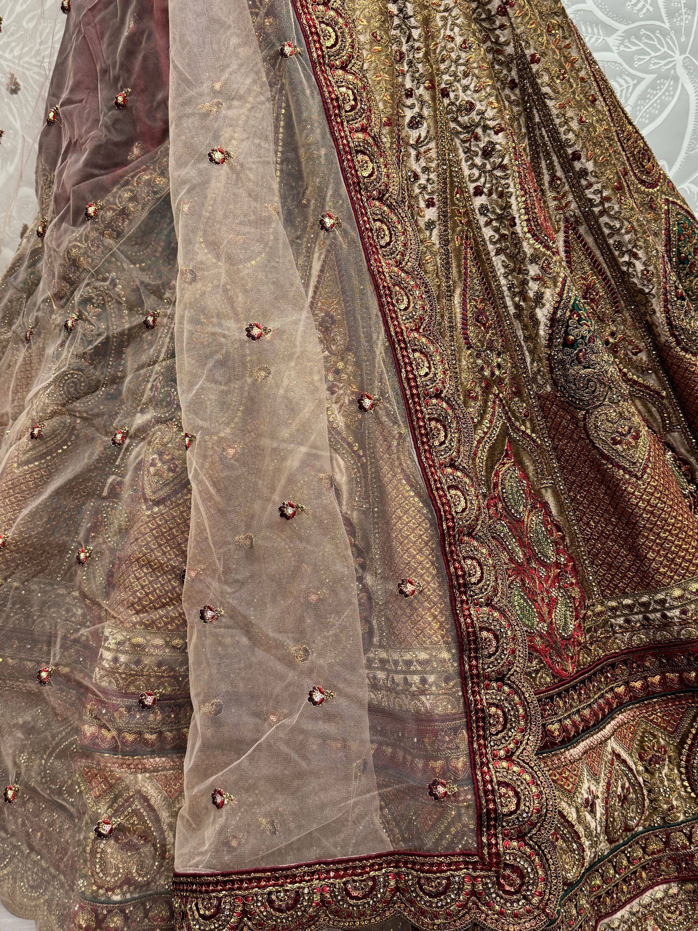 Luxury Indian lehenga choli with intricate gold embroidery, sheer net dupatta, and floral embellishments for weddings.