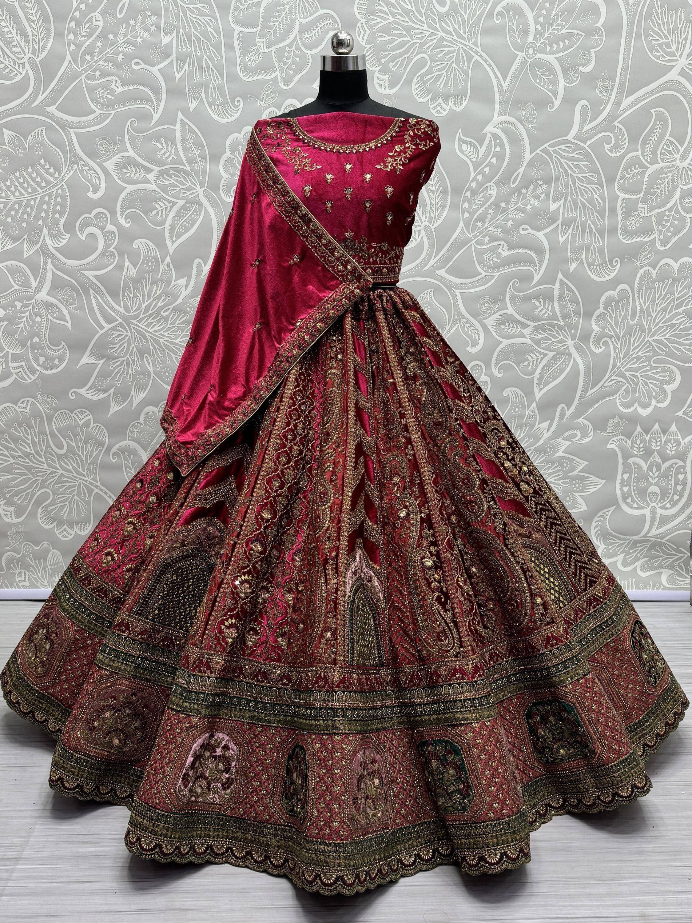 Luxury maroon velvet lehenga choli with gold embroidery, perfect for Indian weddings and festive occasions.