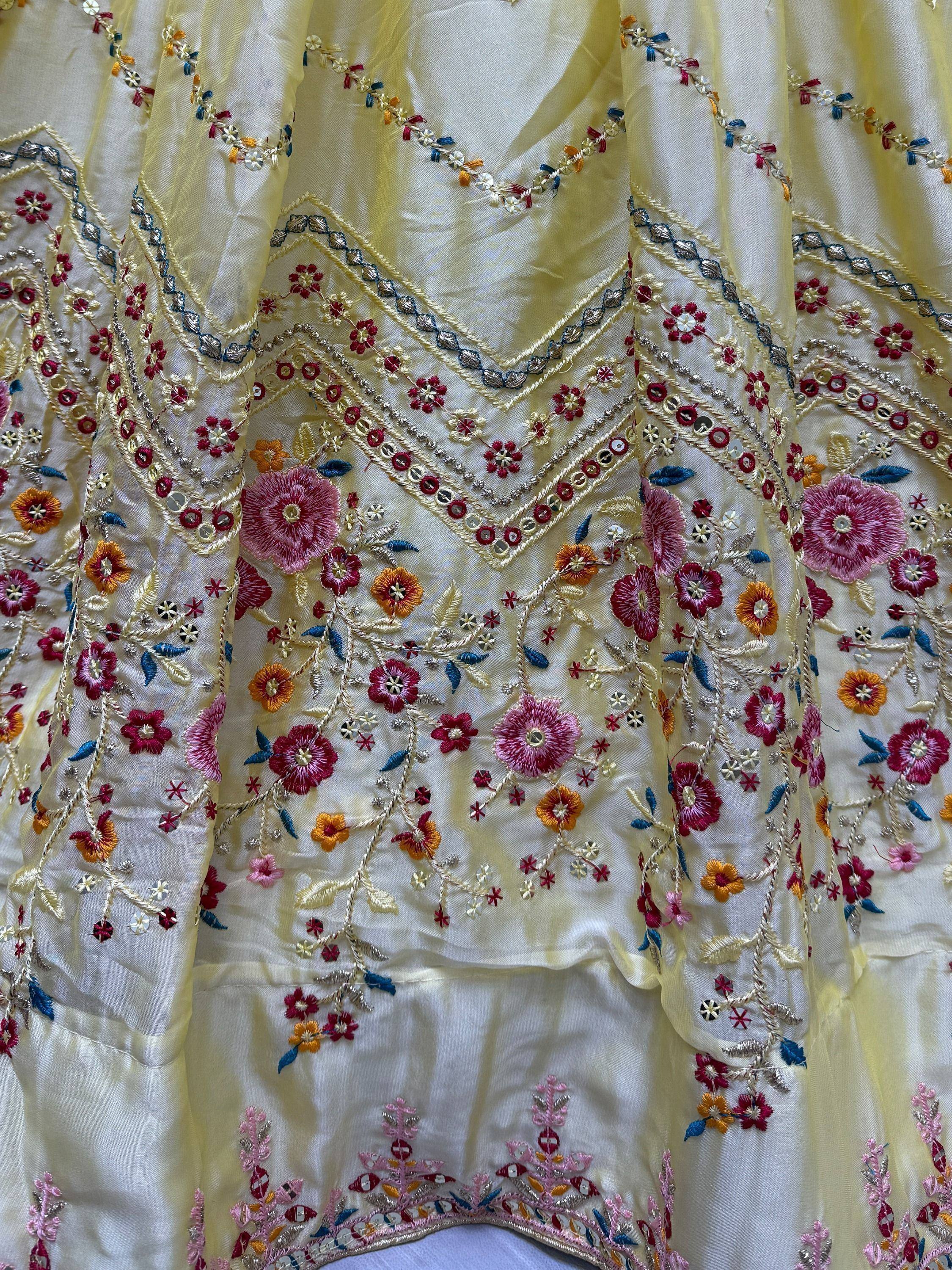 Yellow ethnic gown with floral embroidery and mirror work, perfect for Indian celebrations.