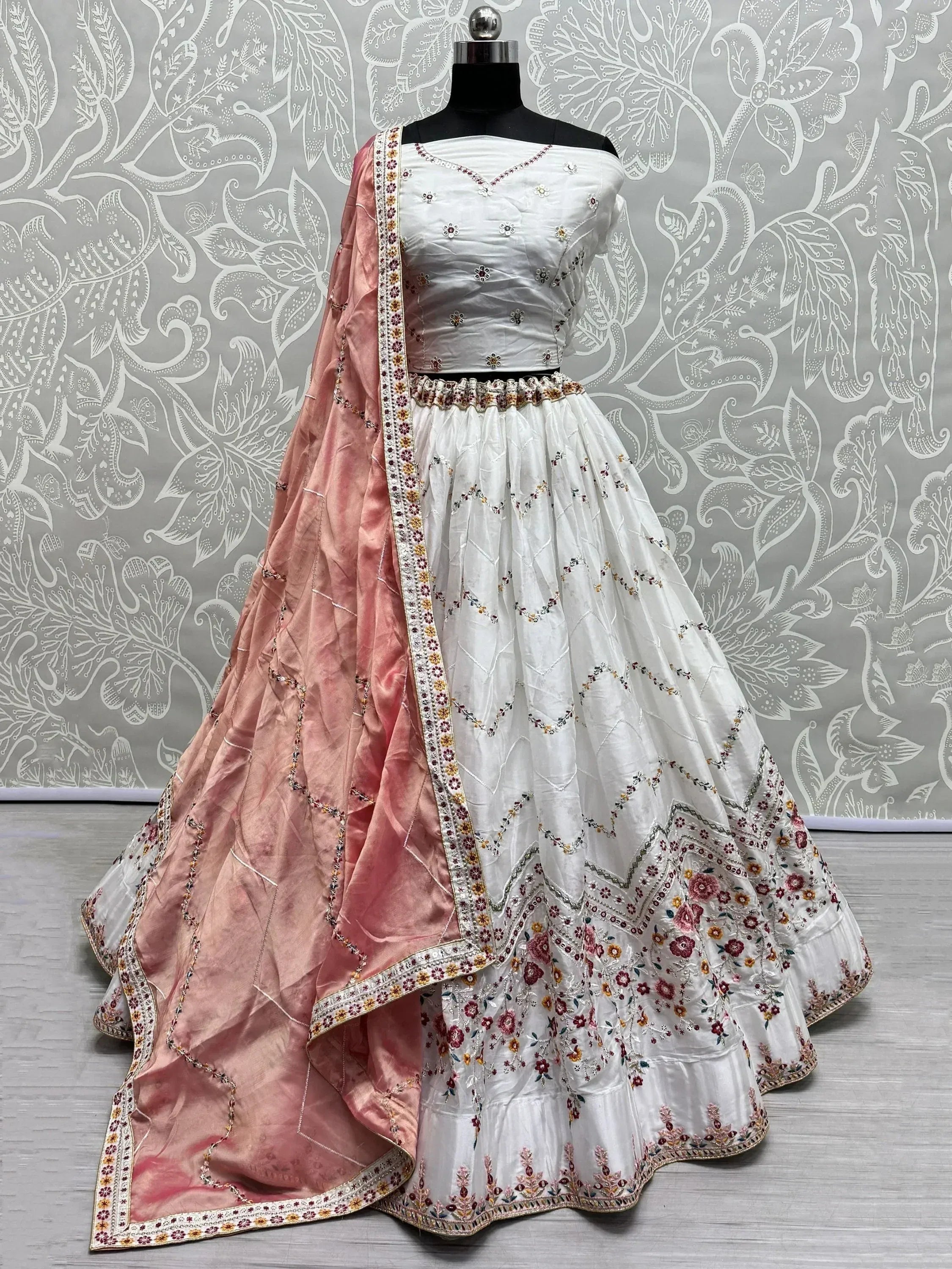 White embroidered lehenga choli with pink dupatta, floral motifs, ethnic Indian wear for weddings and festivals