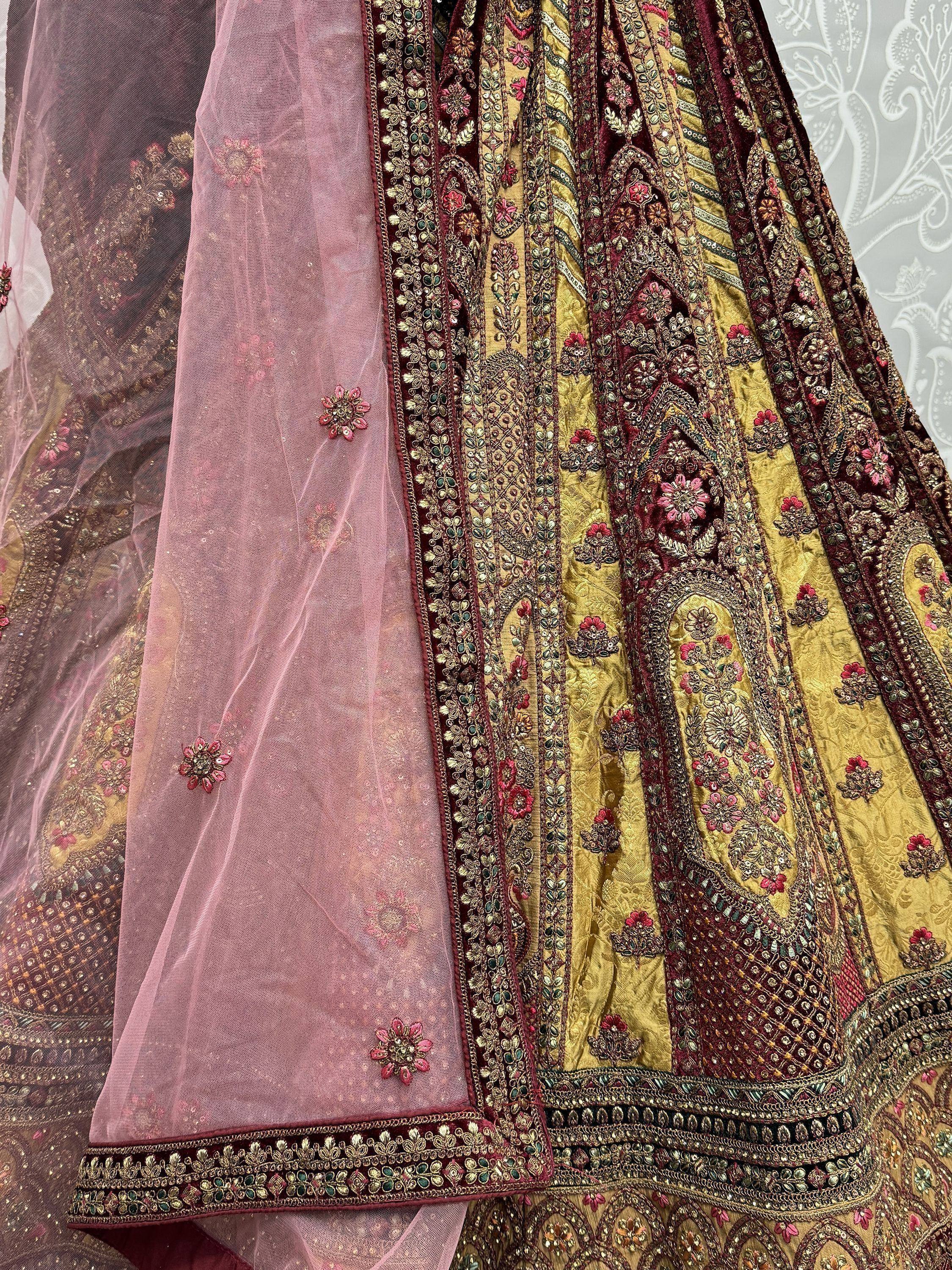 Elegant Indian ethnic lehenga with intricate gold and maroon embroidery, paired with a pink dupatta.