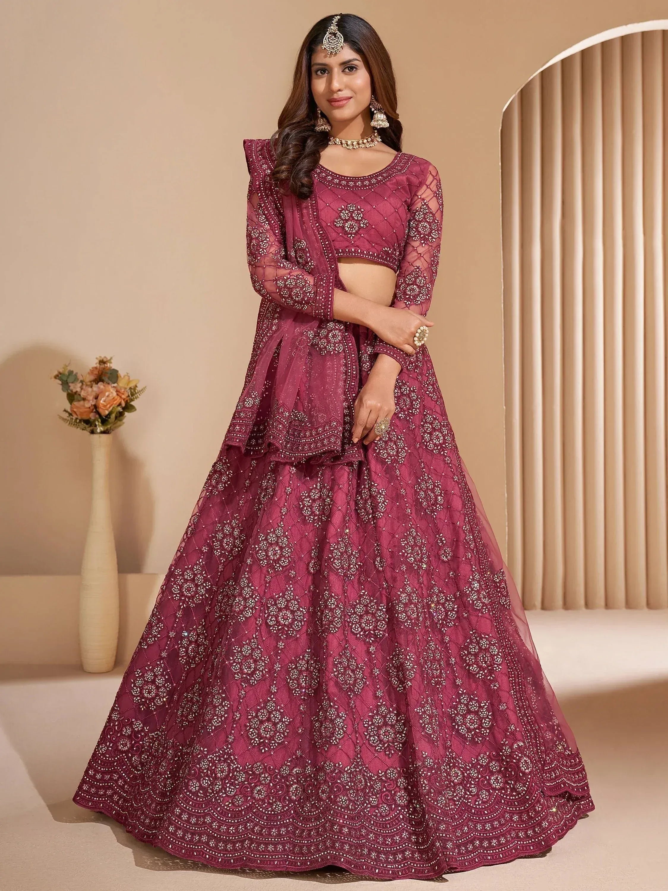 Burgundy embroidered lehenga choli with sheer sleeves and floral motifs, perfect for Indian weddings or festive occasions.