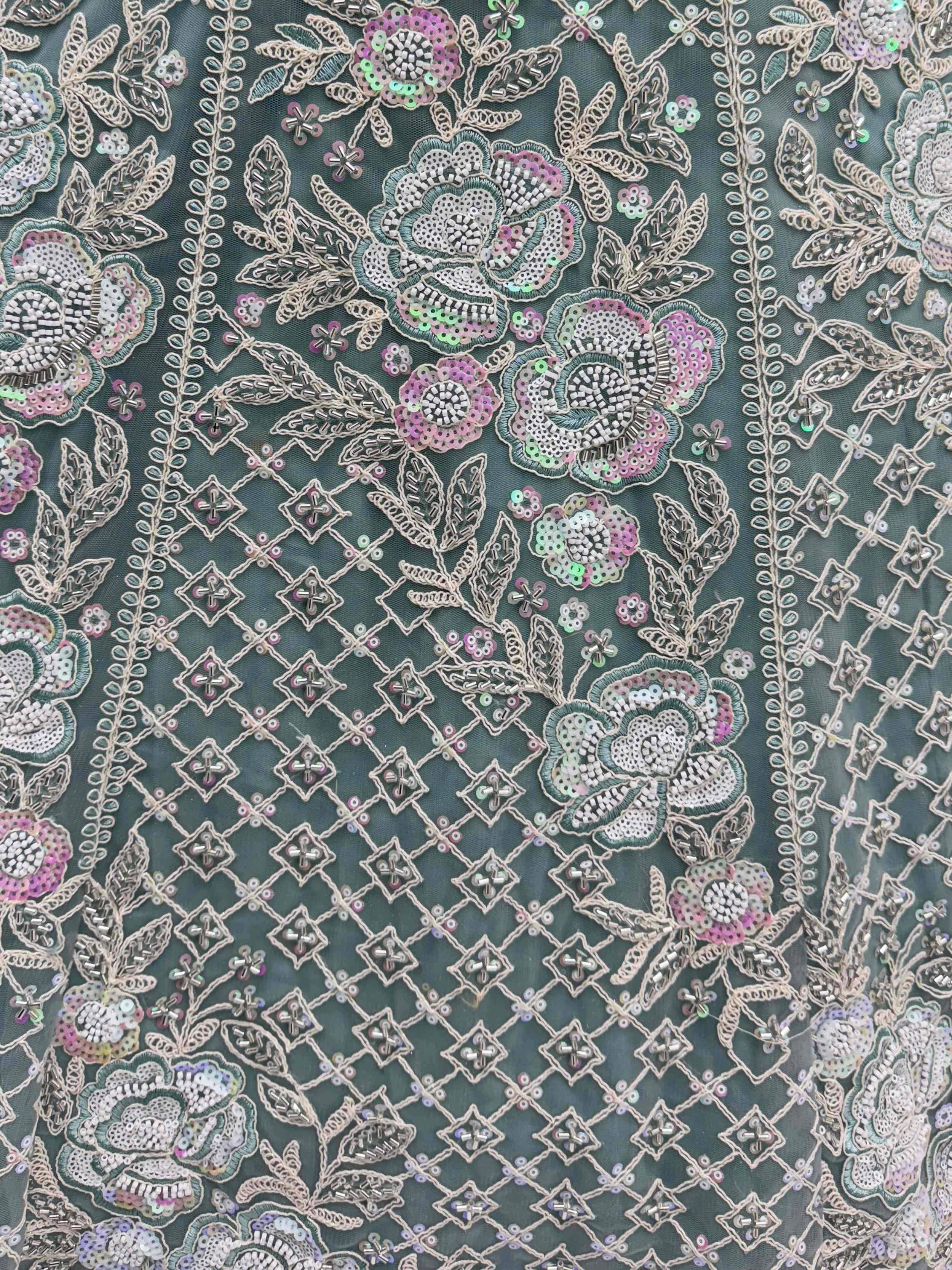 Intricate floral embroidery with beads and sequins on dark green ethnic wear fabric