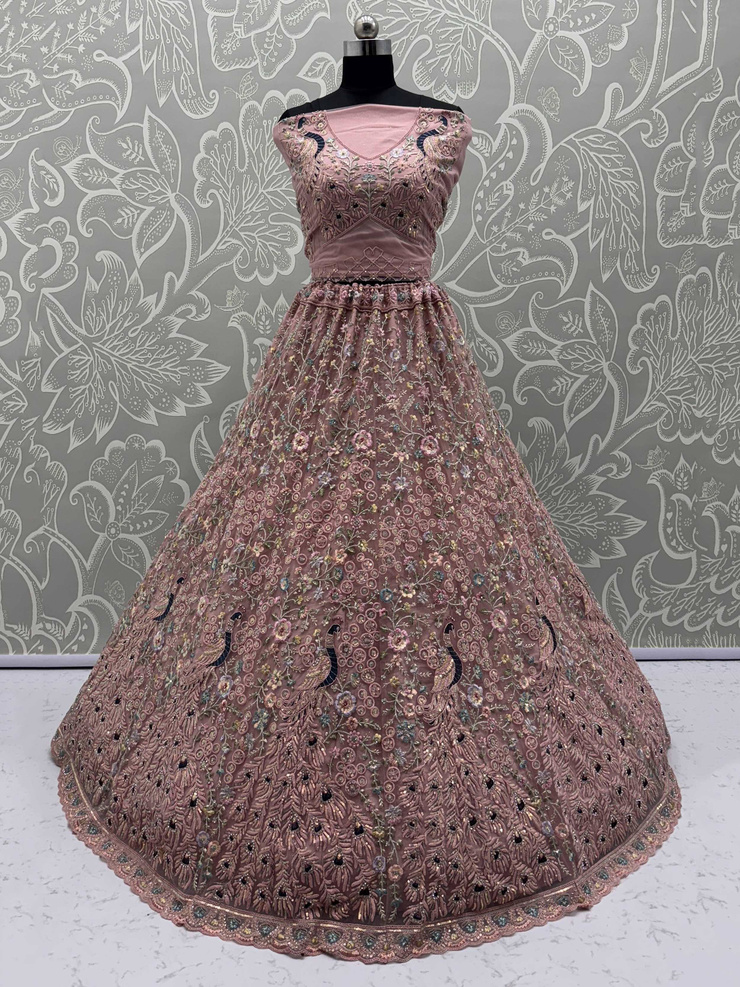 Pink embroidered lehenga choli with peacock motifs, floral detailing, and velvet blouse for Indian ethnic wear