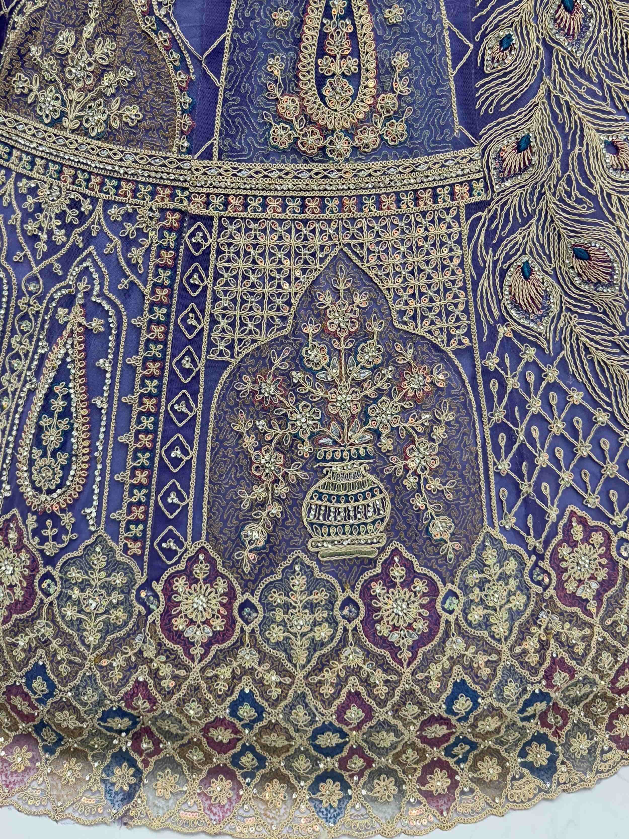 Purple ethnic gown with gold peacock embroidery and floral motifs, perfect for Indian weddings or festive occasions.
