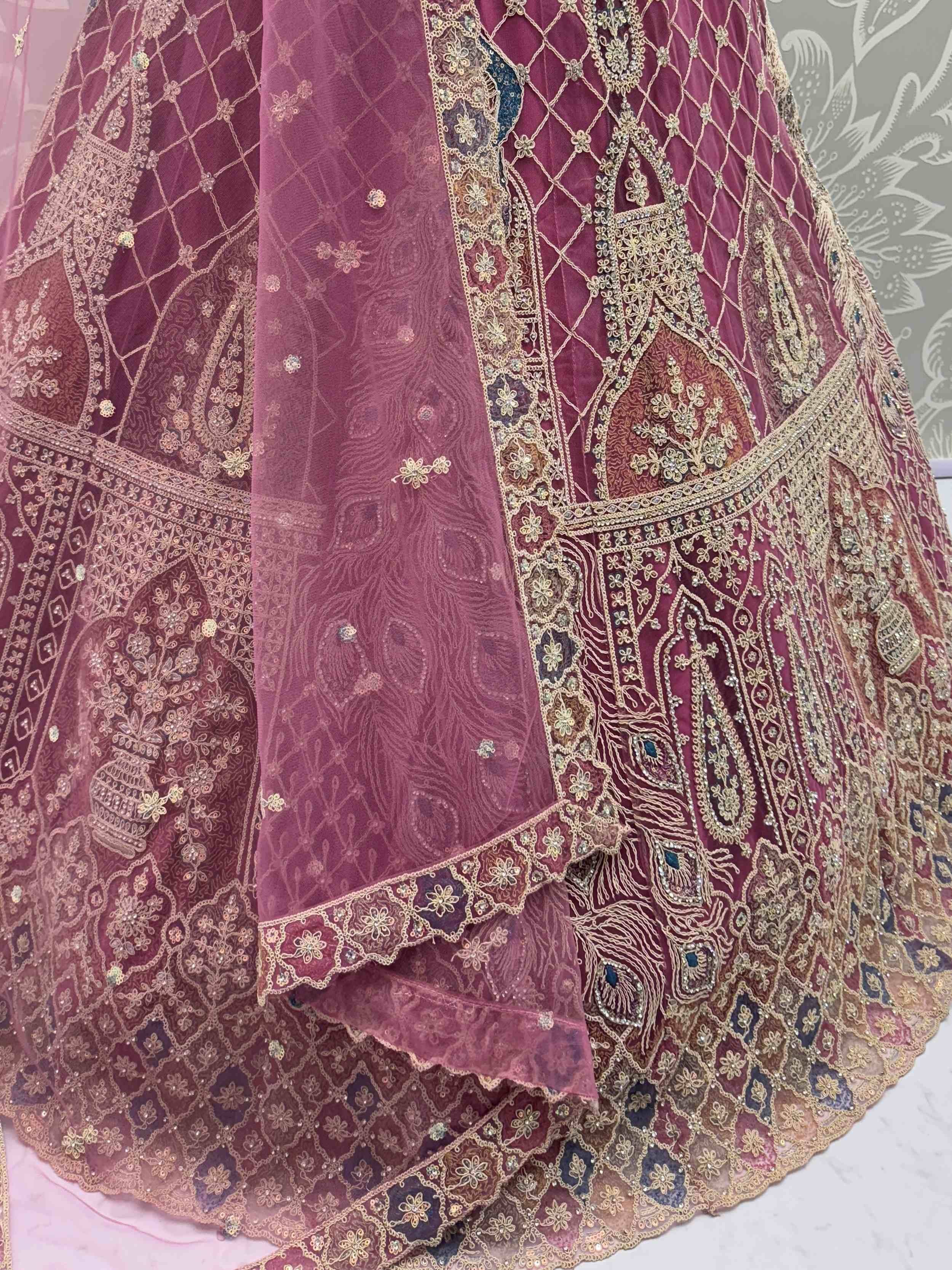 Luxury maroon lehenga choli with intricate gold embroidery and peacock motifs, perfect for Indian weddings.