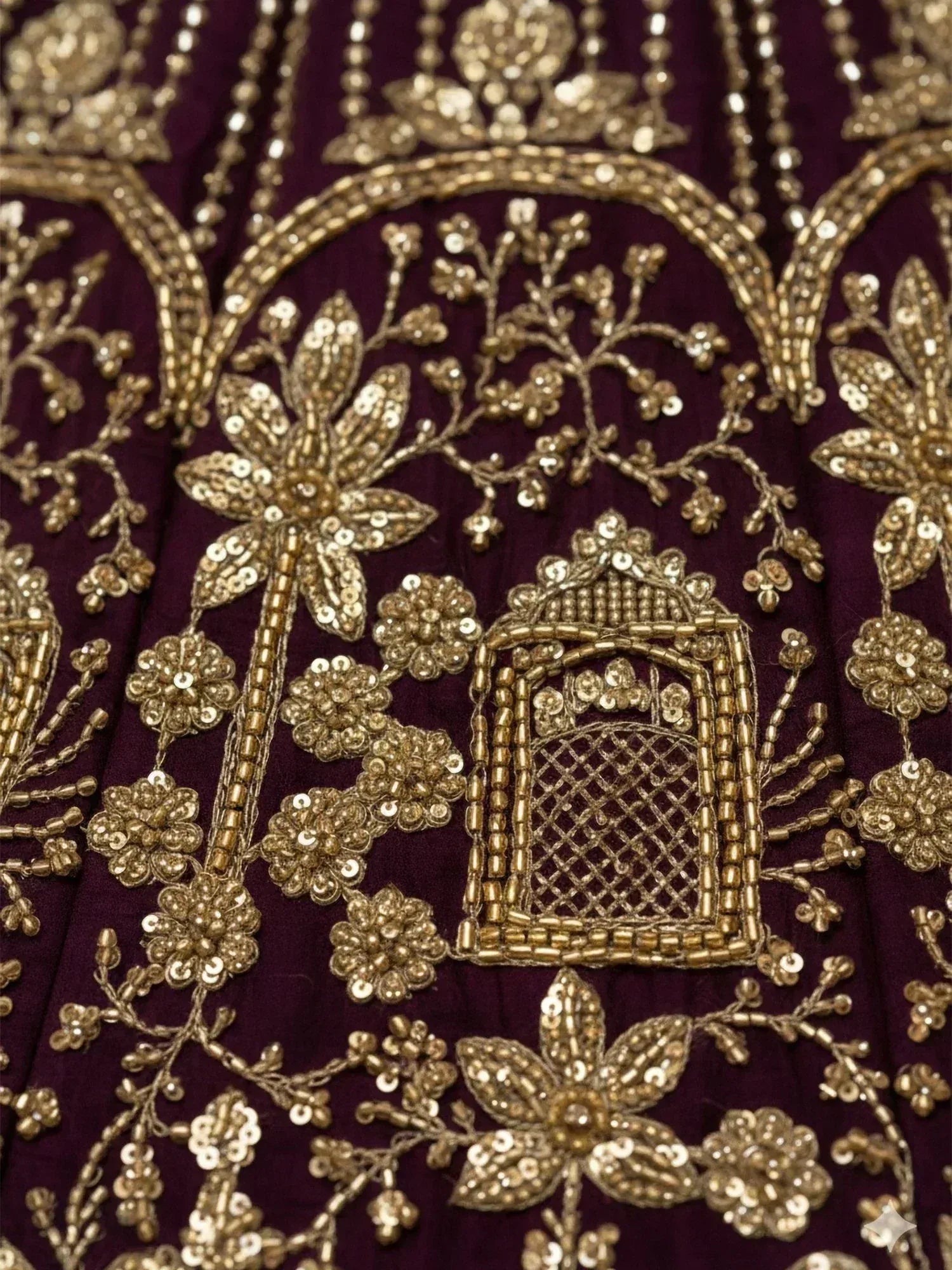 Richly embroidered purple ethnic wear with gold floral and arch motifs, perfect for festive occasions.