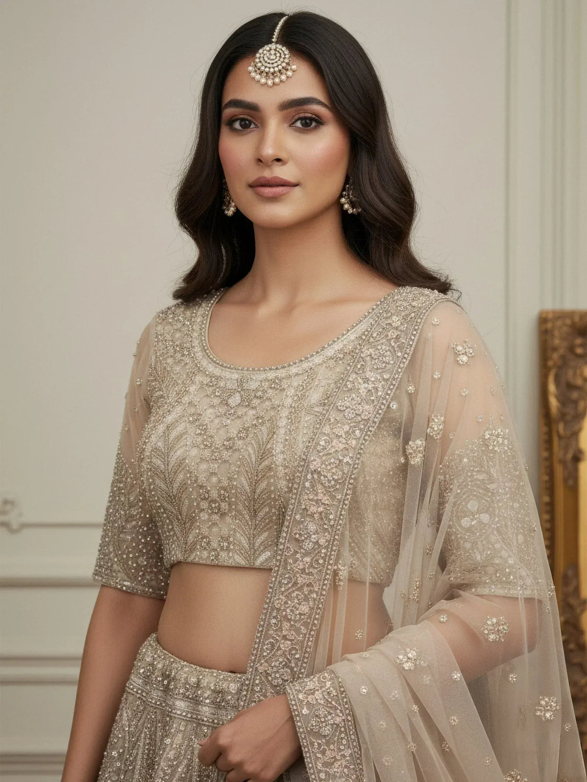 Elegant beige embroidered lehenga choli with sheer dupatta, perfect for Indian weddings and festive occasions.