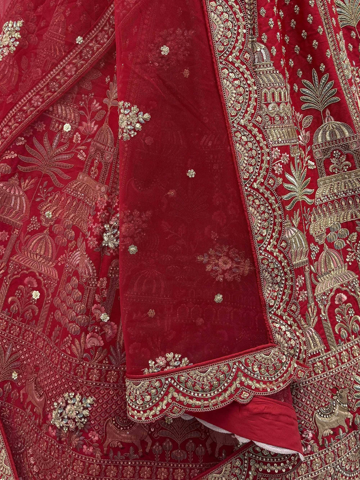 Red velvet lehenga with intricate gold embroidery and temple motifs, perfect for Indian ethnic wear.