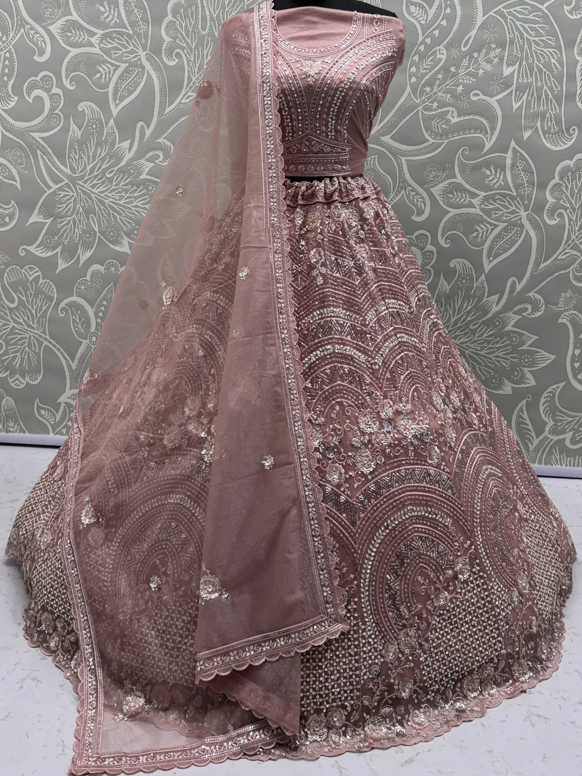 Dusty rose designer lehenga choli with heavy embroidery and matching dupatta, ideal for weddings and parties
