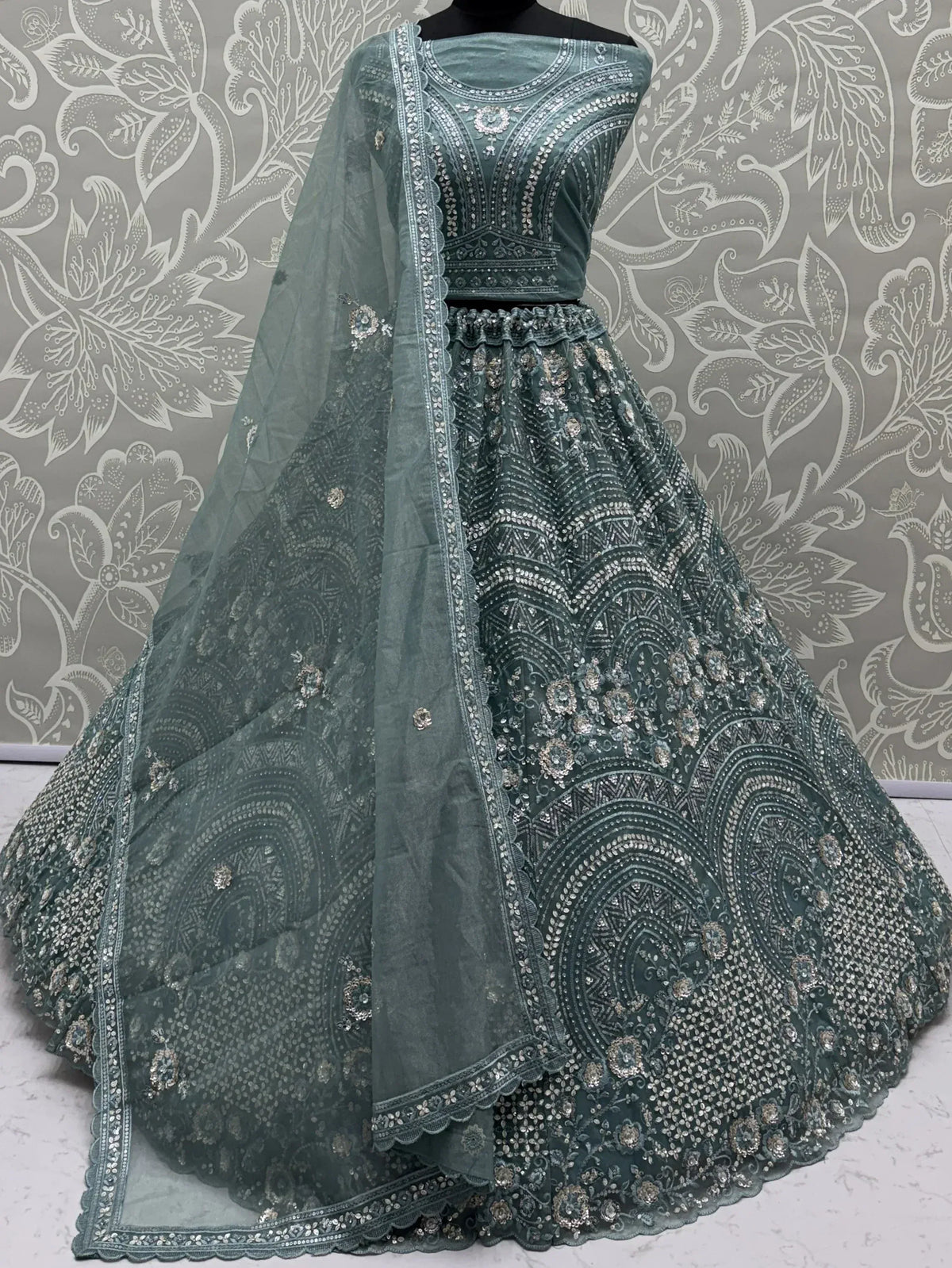 Emerald green designer lehenga choli with heavy silver embroidery and matching dupatta, perfect for weddings and festive occasions.