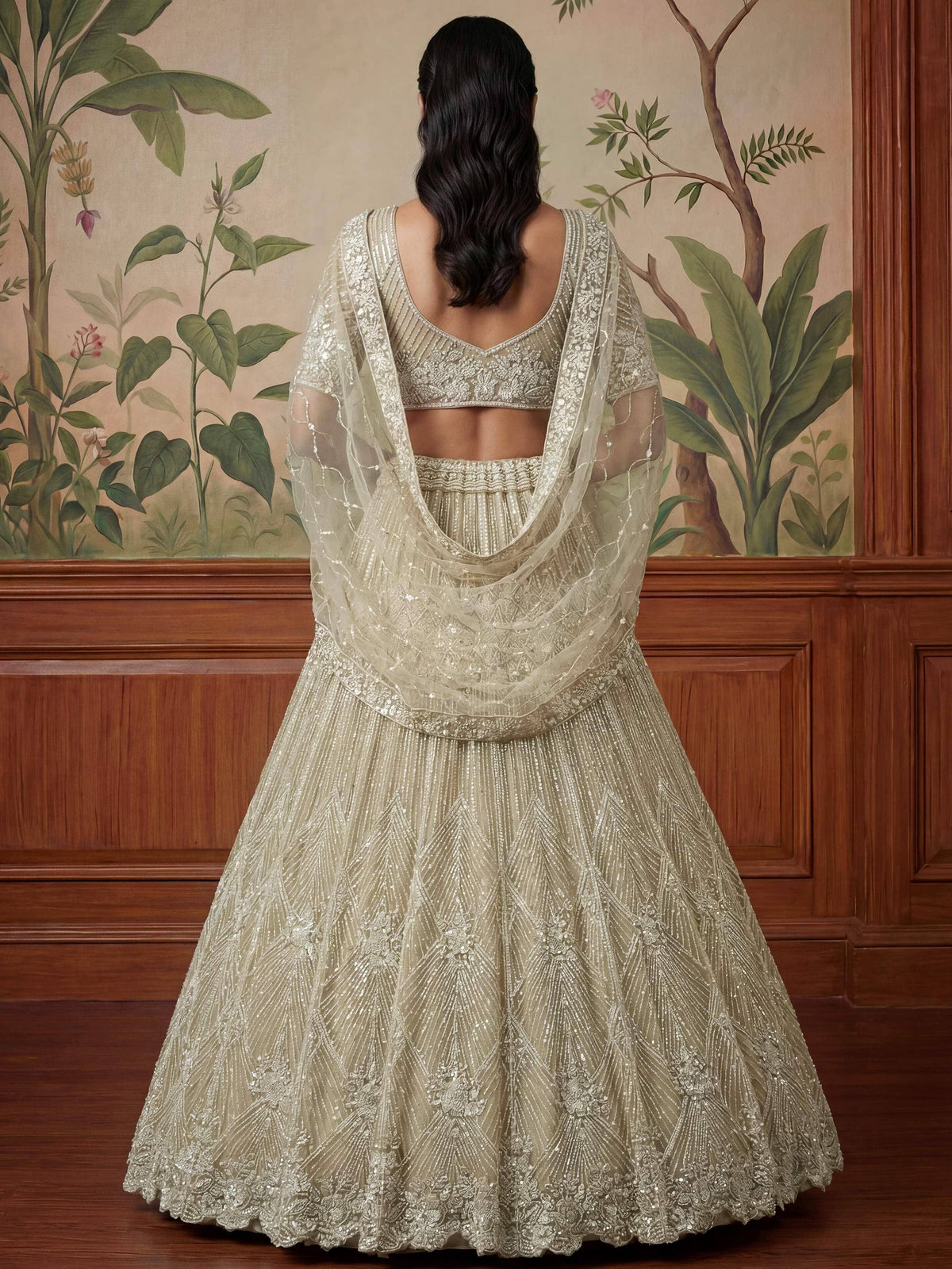 Elegant beige designer lehenga choli with intricate embroidery and sheer dupatta, perfect for Indian weddings.