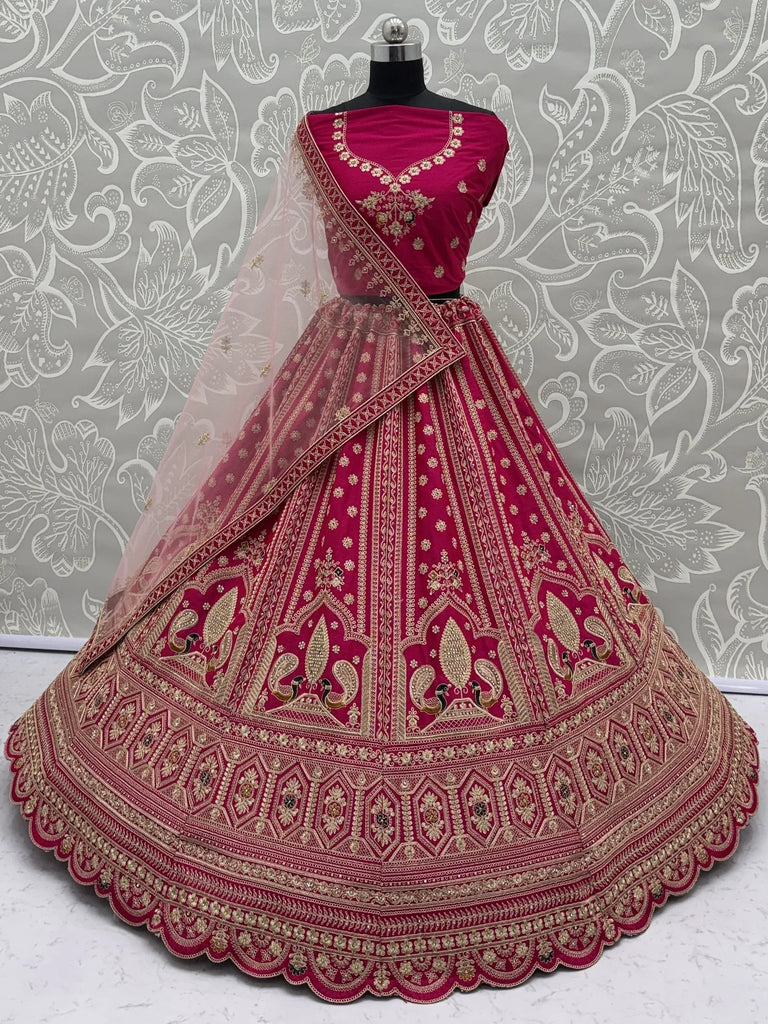 Intricately embroidered magenta designer lehenga choli with a sheer dupatta on a mannequin