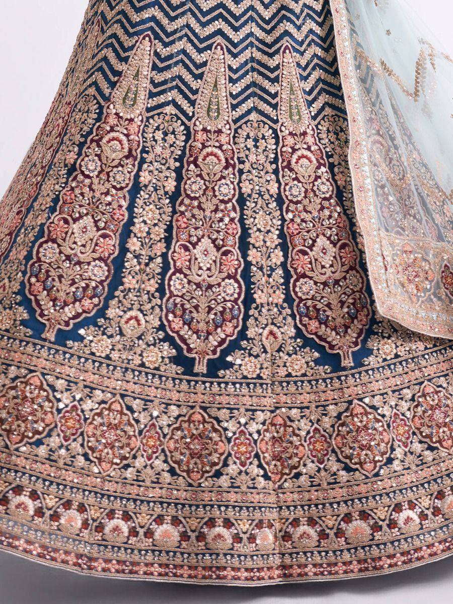 Blue designer lehenga with intricate gold and maroon embroidery, floral motifs, and sheer dupatta