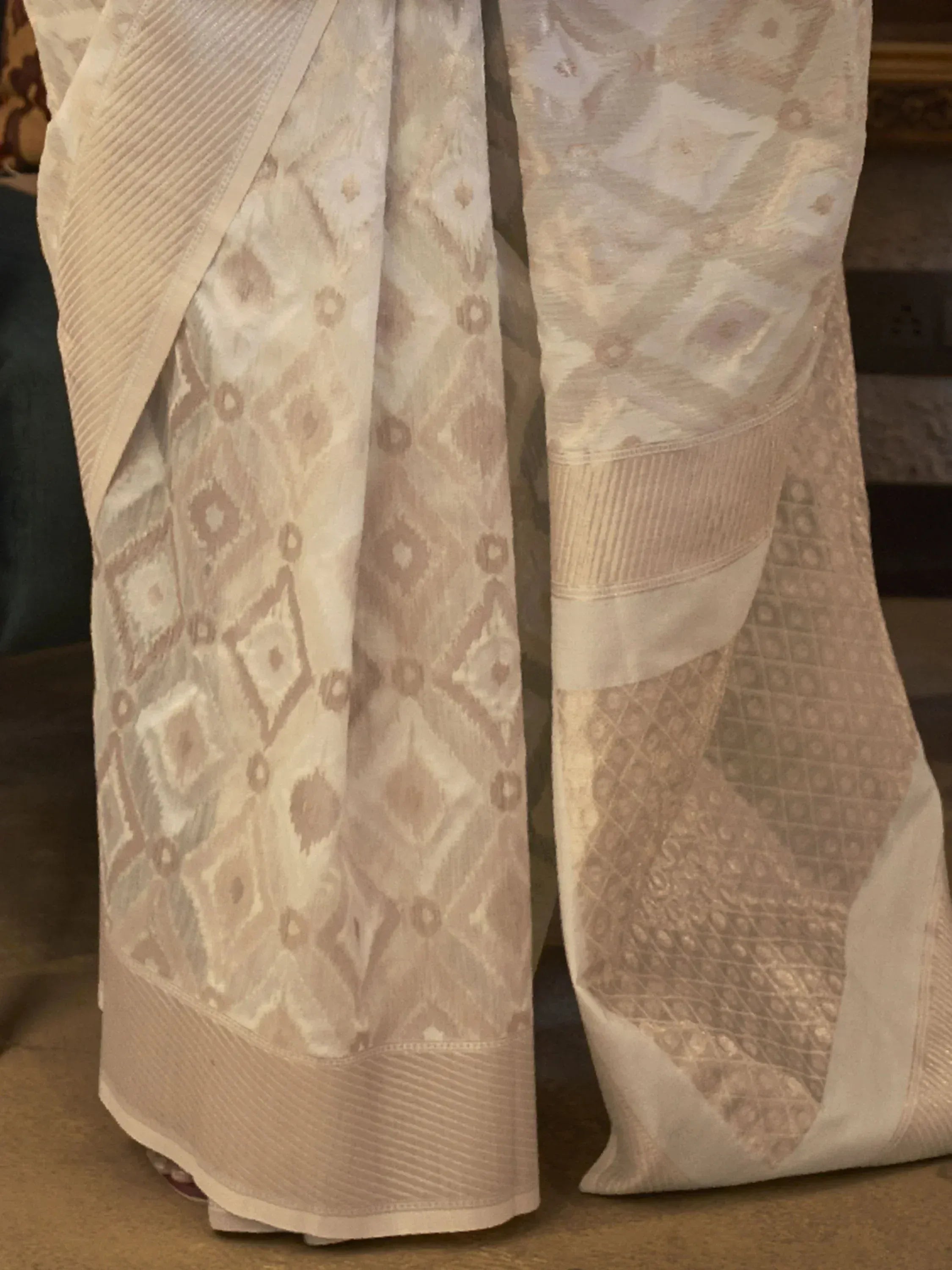 Cream ethnic saree with geometric ikat print and pleated border, ideal for Indian occasions