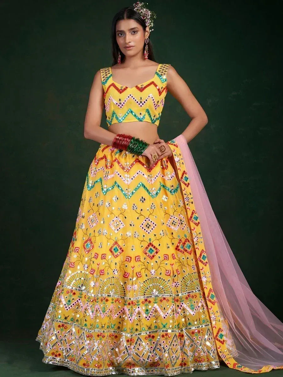Yellow embroidered lehenga choli with mirror work, perfect for Indian ethnic wear and festive occasions.