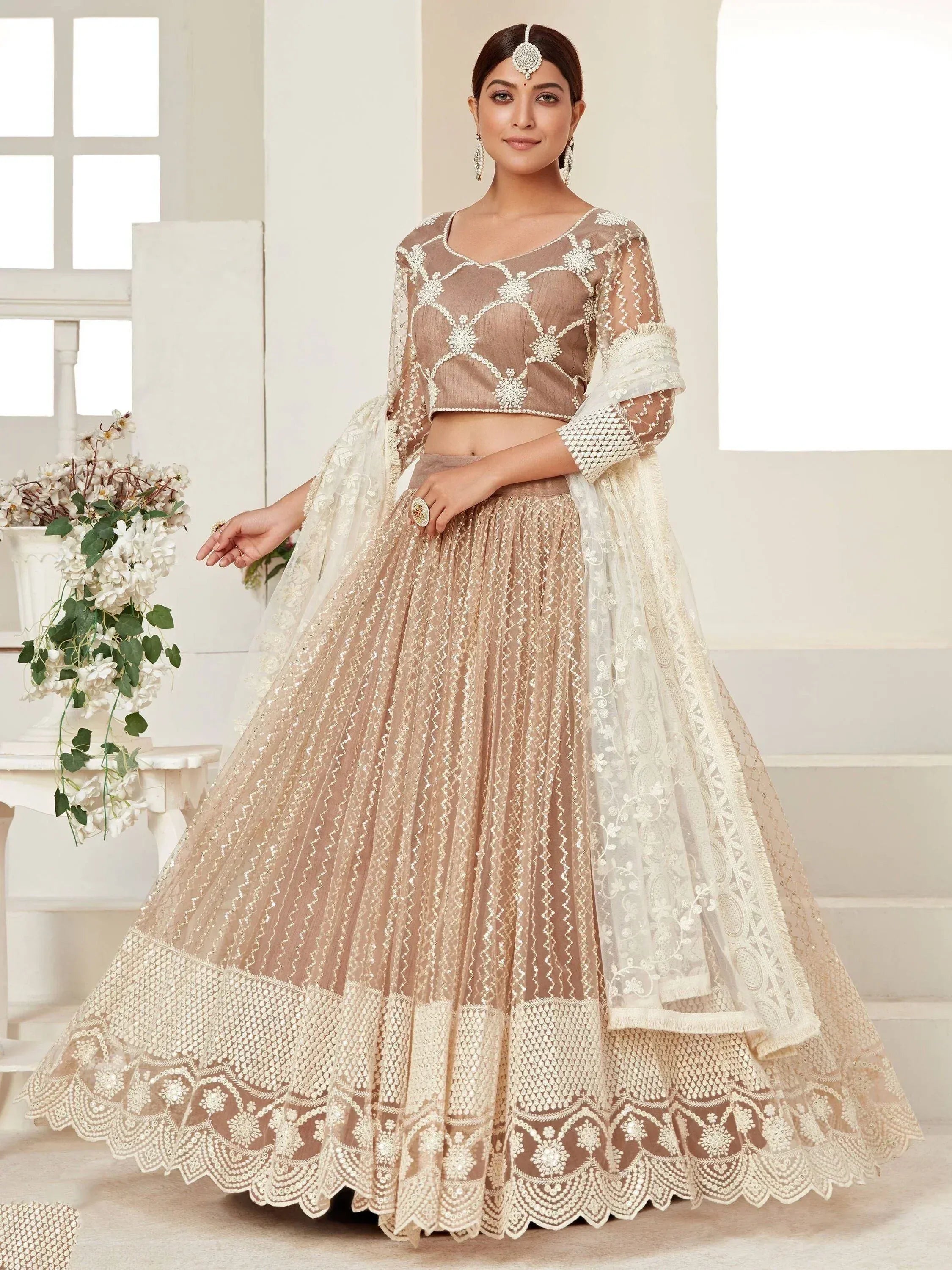 Elegant beige embroidered lehenga choli with sheer dupatta, perfect for Indian weddings and festive occasions.