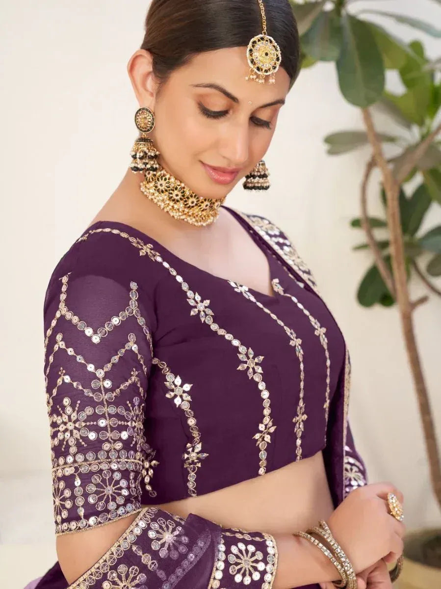 Purple ethnic blouse with mirror and gold embroidery, paired with traditional Indian jewelry