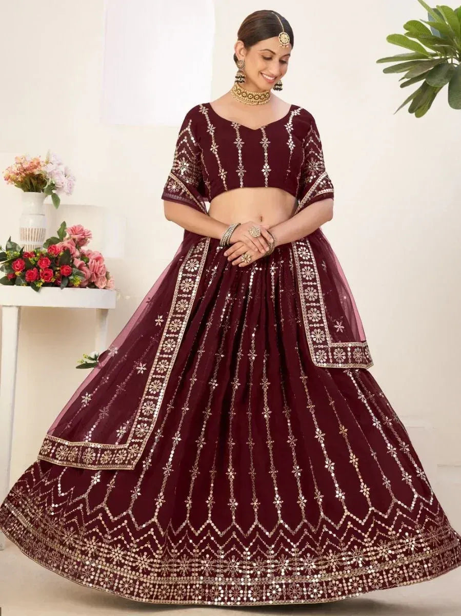 Maroon designer lehenga choli with gold embroidery and mirror work, perfect for Indian weddings and festive occasions.
